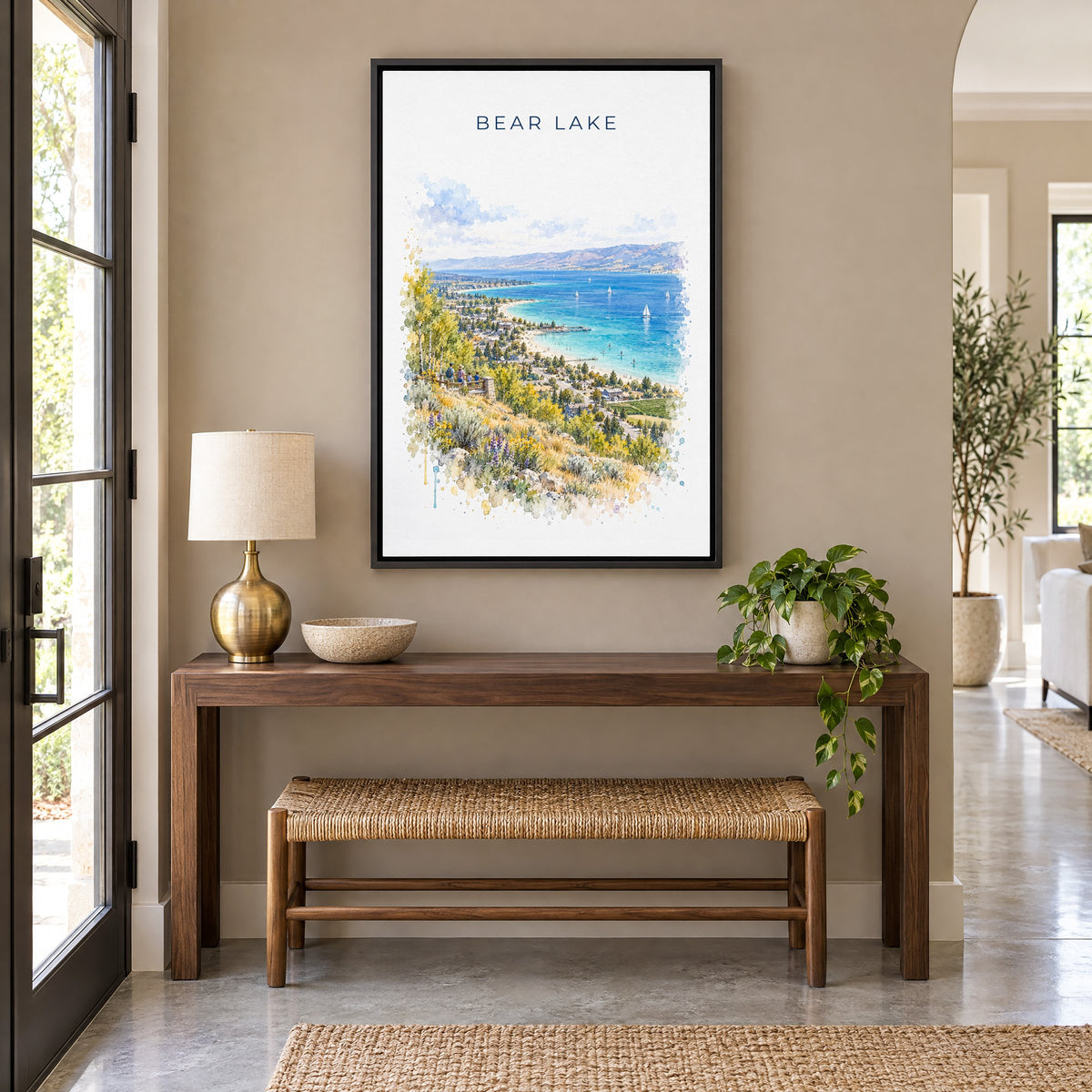 Bear Lake watercolor print as a black floater canvas above a walnut console and woven bench in an entryway