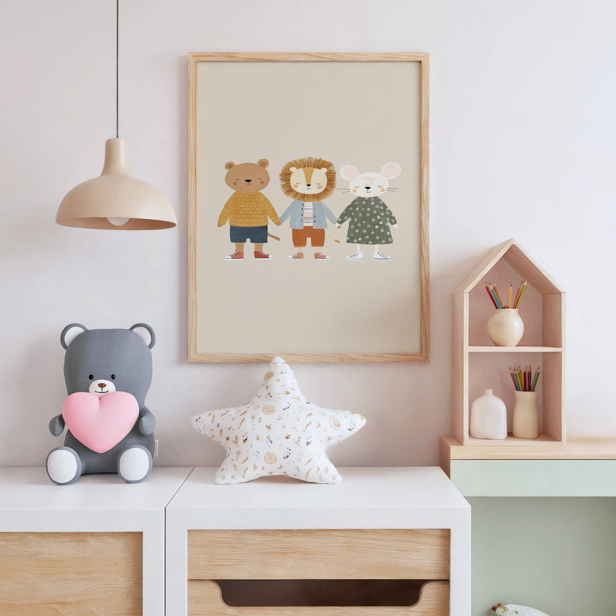 Three friends holding hands nursery print in an oak frame above a white dresser with a star pillow and house shelf