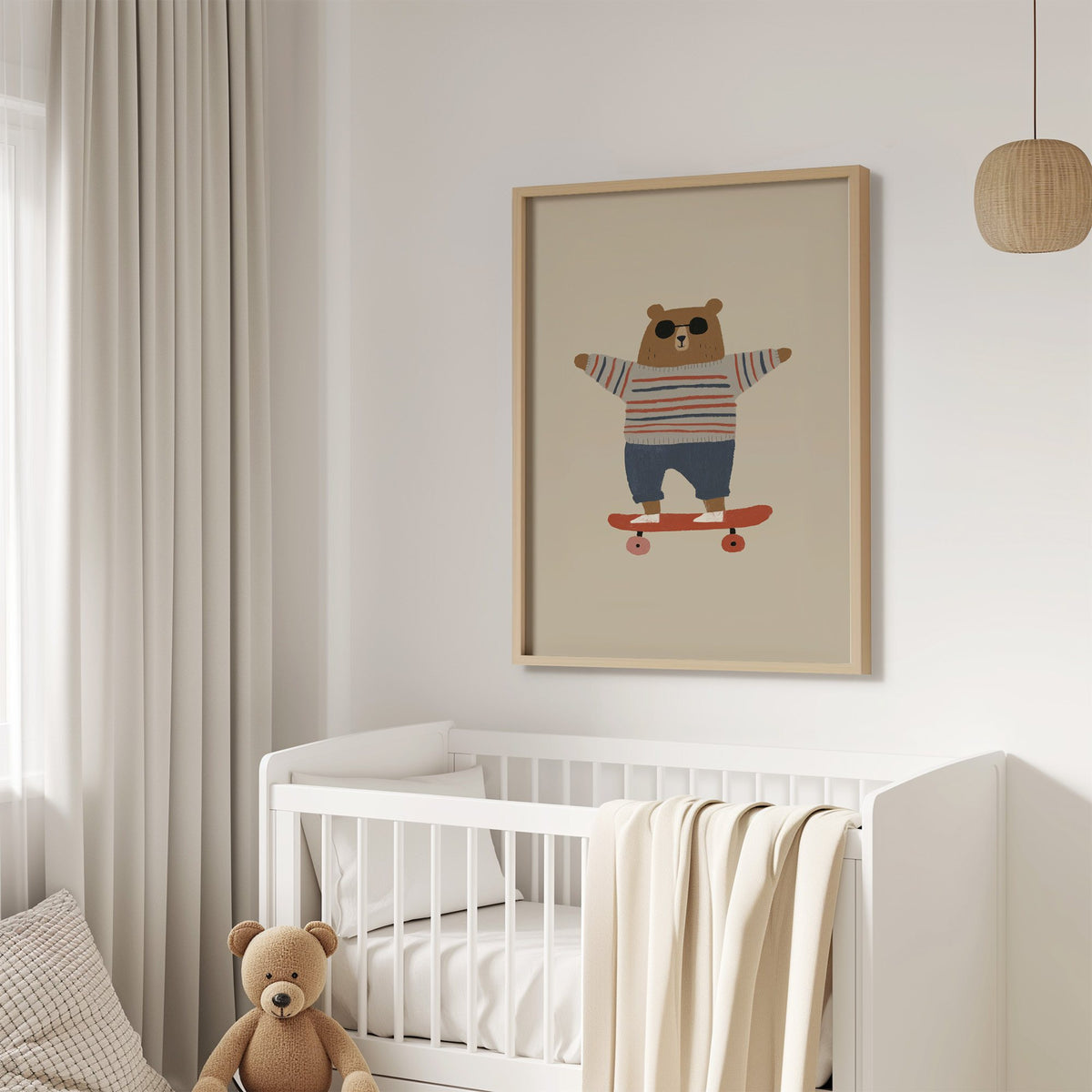 Skateboard bear striped sweater nursery print in an oak frame above a white crib with a teddy bear