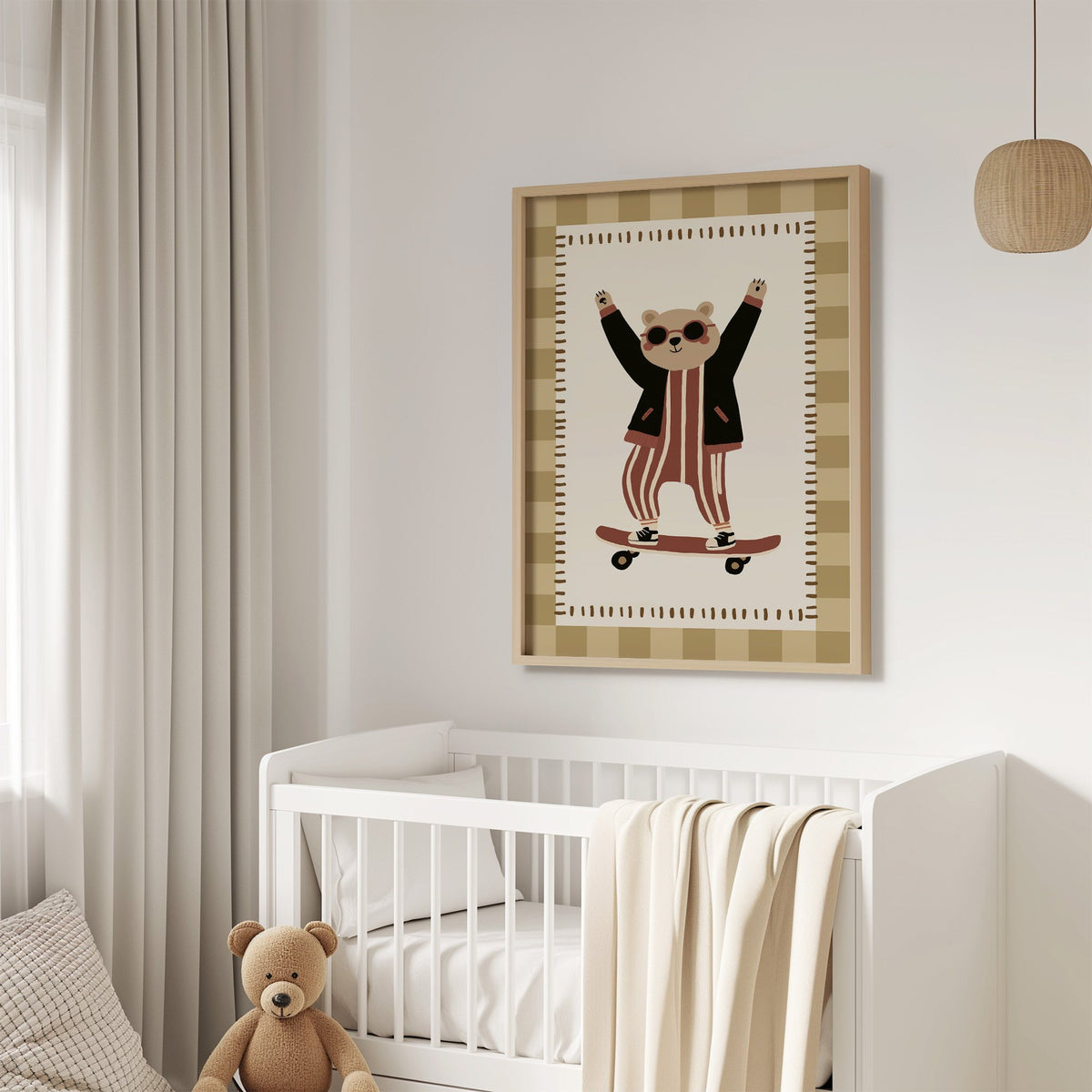 Skateboard bear checker border nursery print in an oak frame above a white crib with a teddy bear