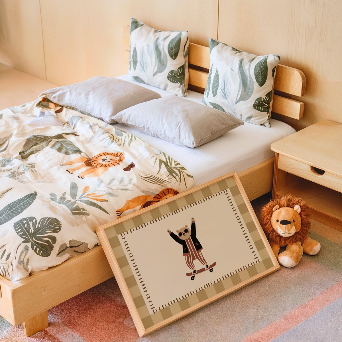 Landscape skateboard bear checker border nursery print in an oak frame leaning on a kids bed by a lion plush