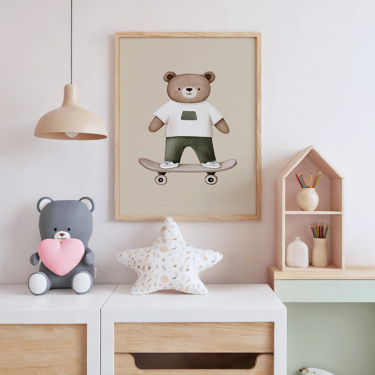 Skateboard bear white tee nursery print in an oak frame above a white dresser with a star pillow and house shelf