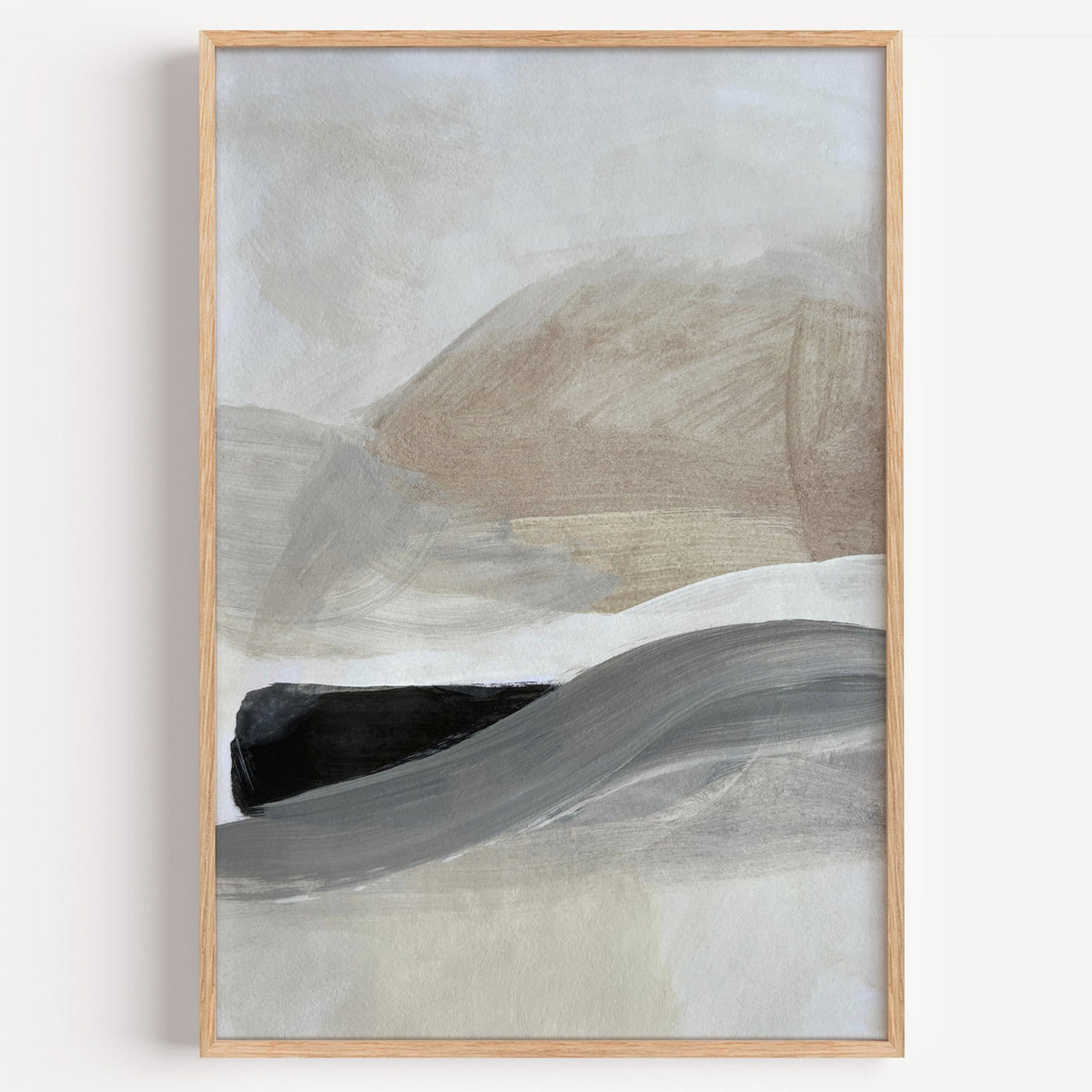 Beige hills and gray black wave abstract print in a light oak frame on a plain white wall