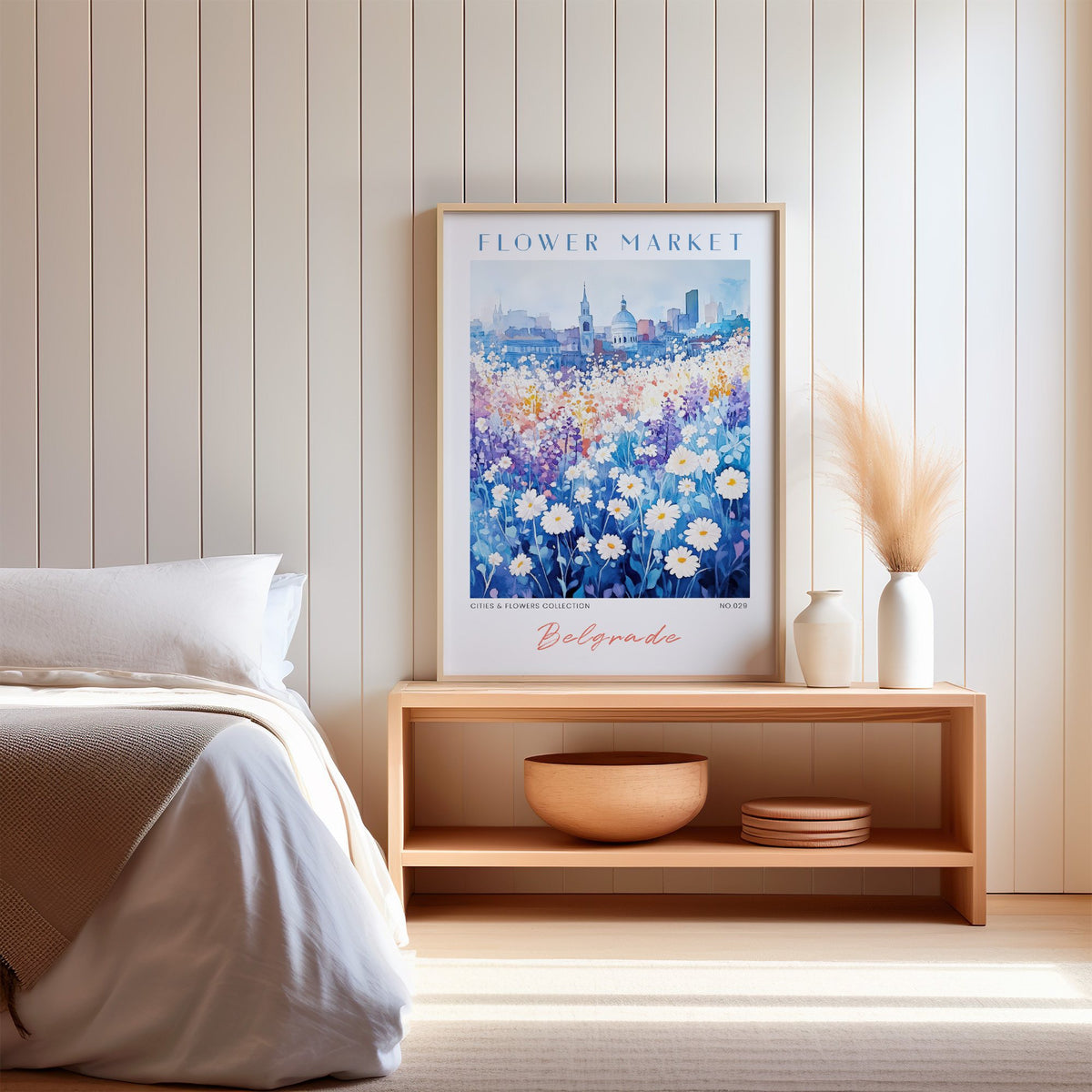 Belgrade flower market print in an oak frame on a wood bench against a white shiplap bedroom wall with pampas grass