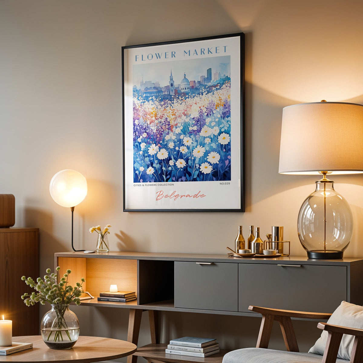 Belgrade flower market print in a black frame above a grey media console with a glass table lamp