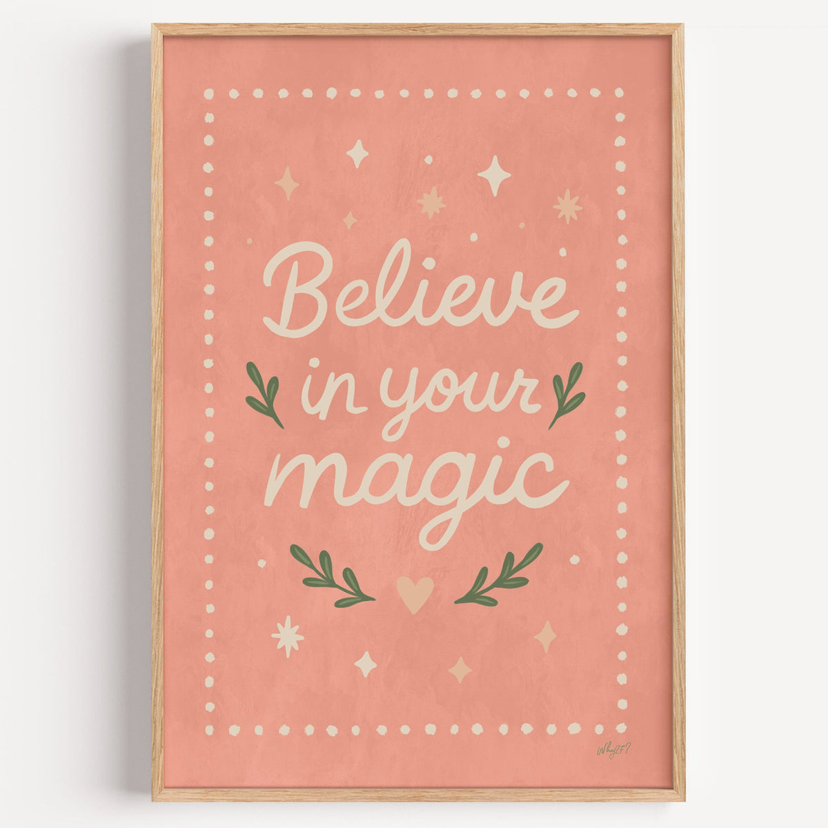 Believe in your magic coral quote nursery print in a light oak frame on a plain white wall