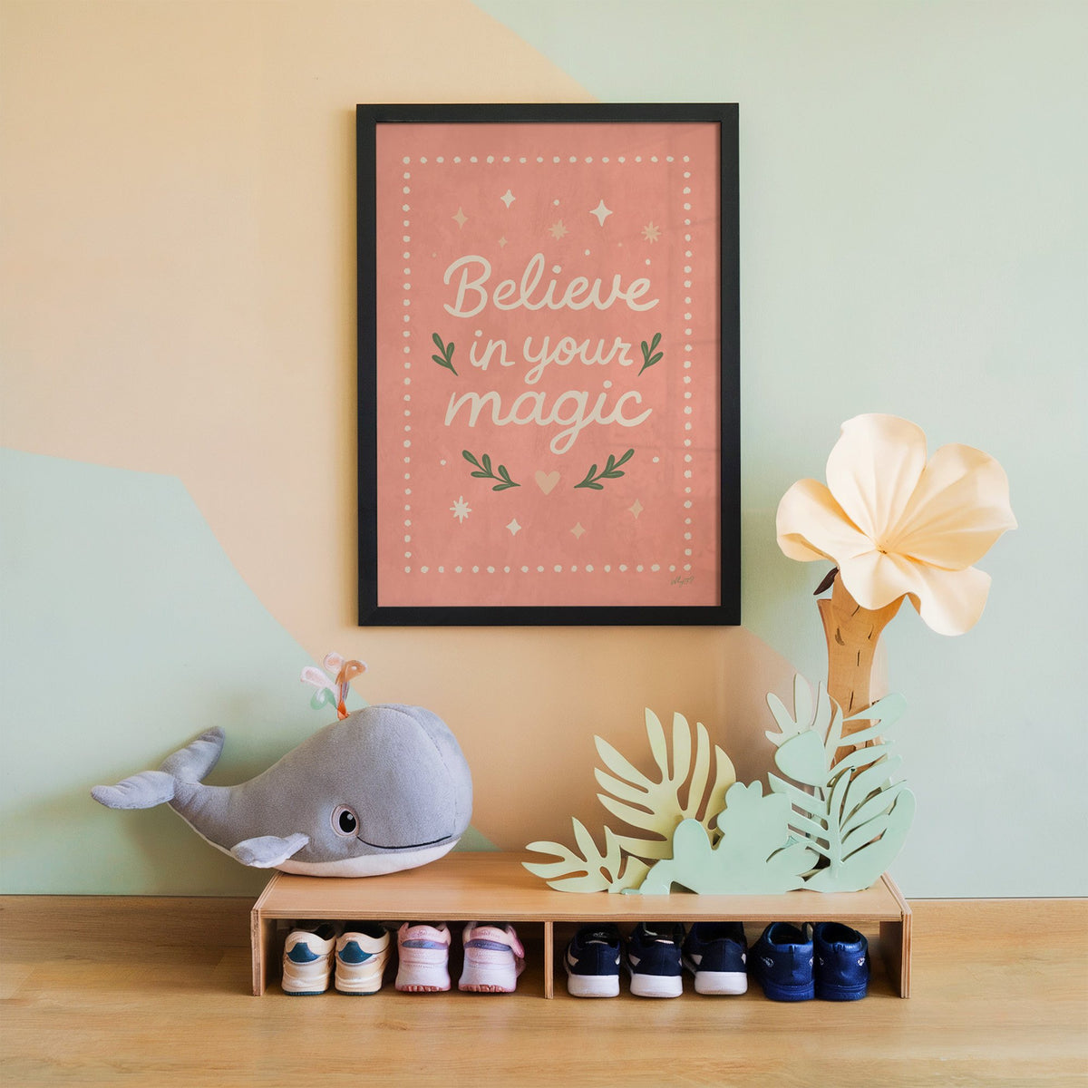 Believe in your magic coral quote nursery print in a black frame on a mint and peach wall above a whale plush