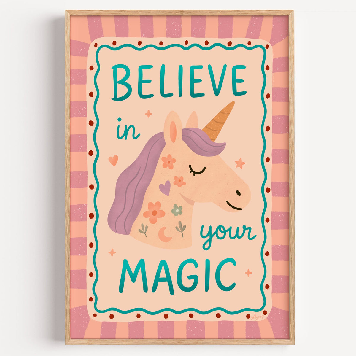 Believe in your magic unicorn nursery print in a light oak frame on a plain white wall