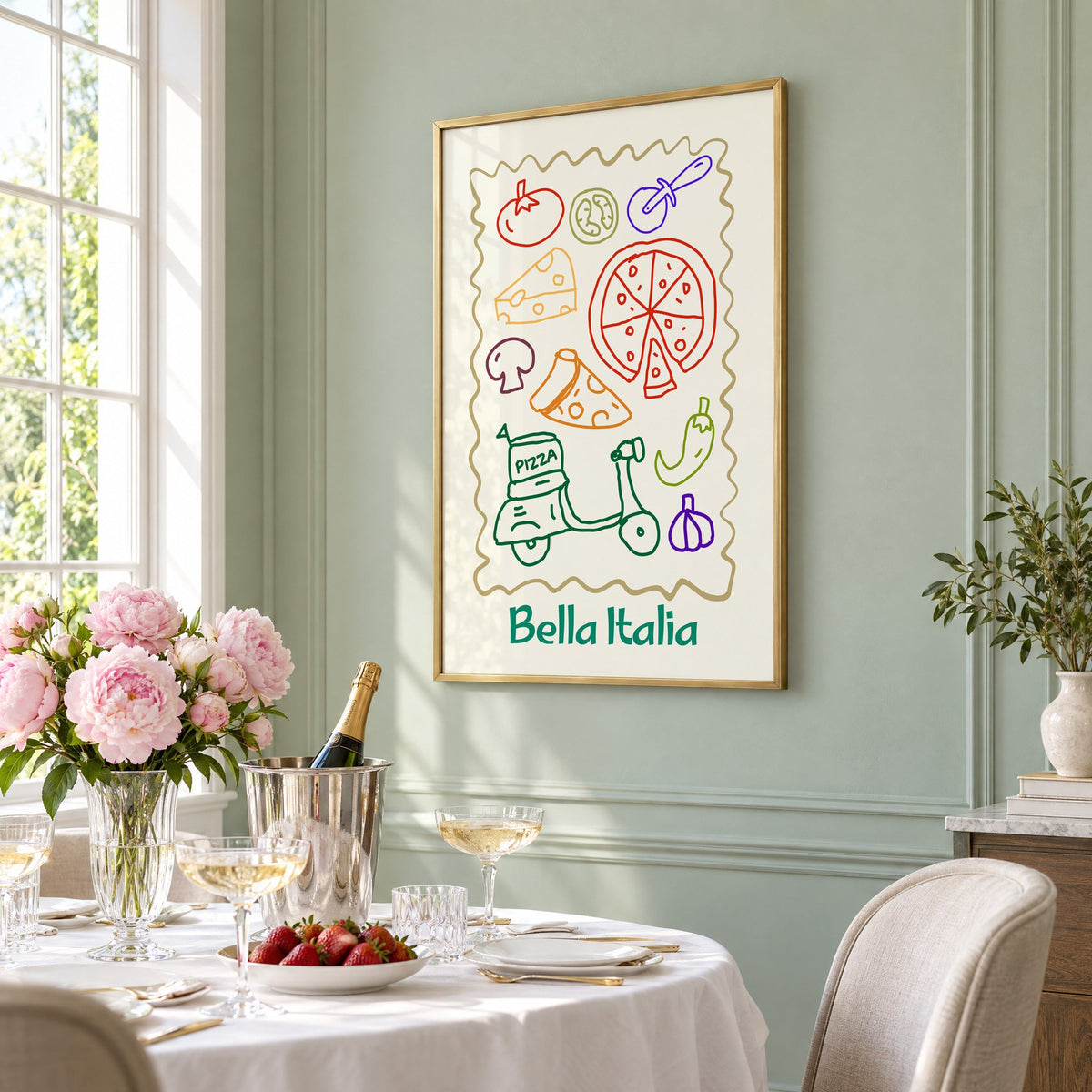 Bella Italia pizza scooter doodle print in a brass frame on a sage wall above a brunch table with champagne and peonies, seen at an angle