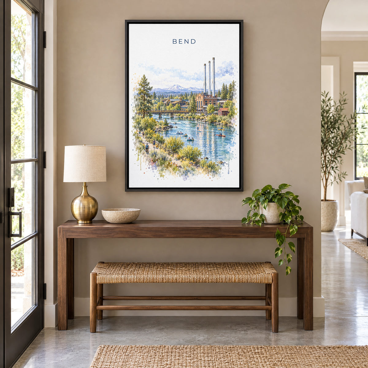 Bend, Oregon watercolor print as a black floater canvas above a walnut console and woven bench in an entryway