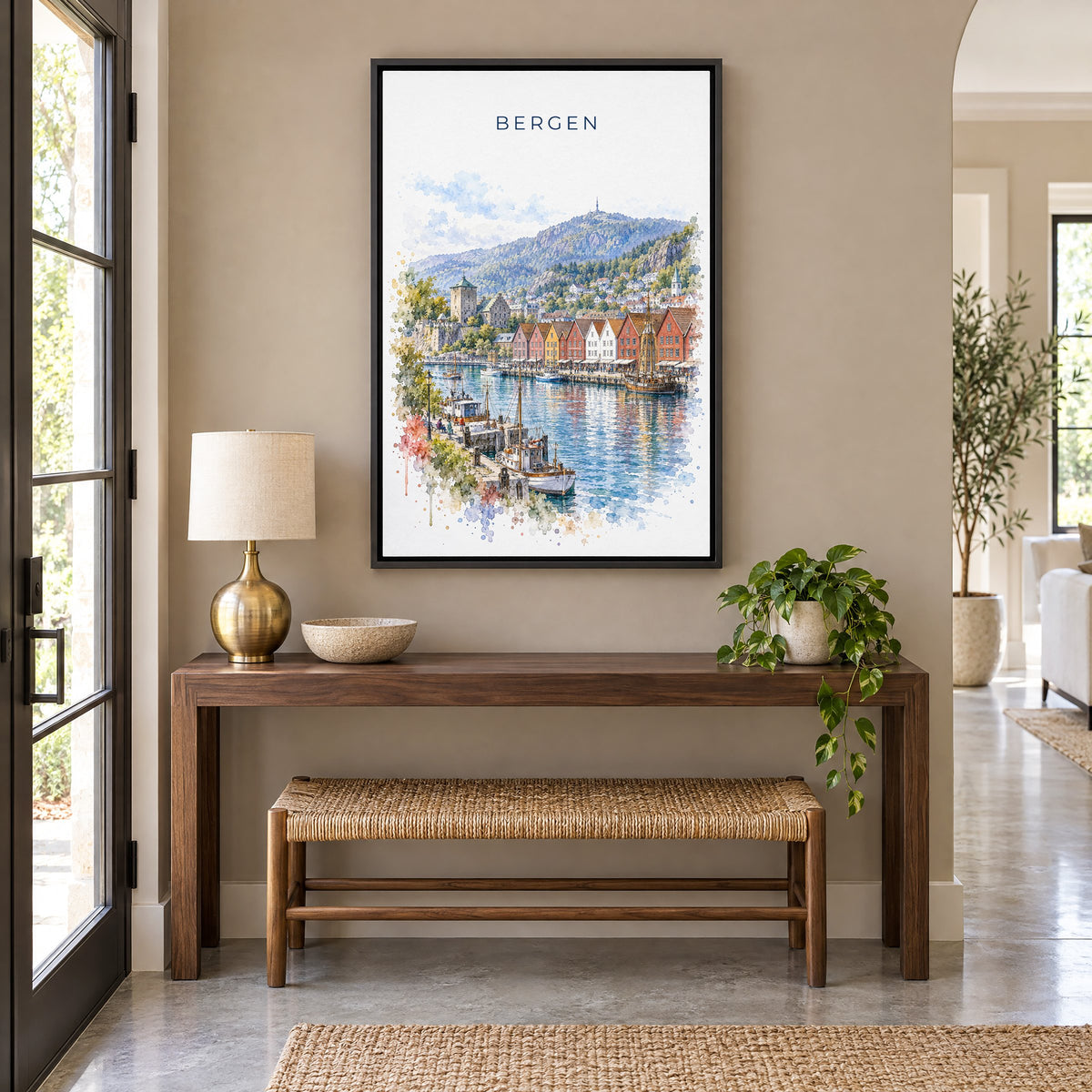 Bergen, Norway watercolor print as a black floater canvas above a walnut console and woven bench in an entryway