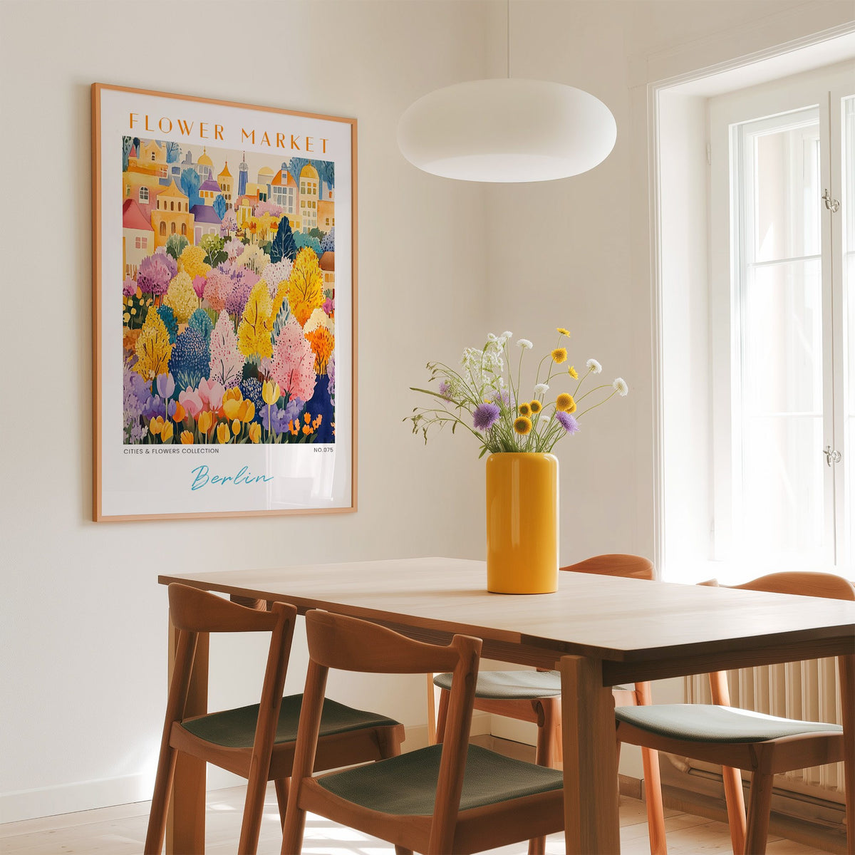 Berlin flower market print in an oak frame above a dining table with a yellow vase and white pendant light