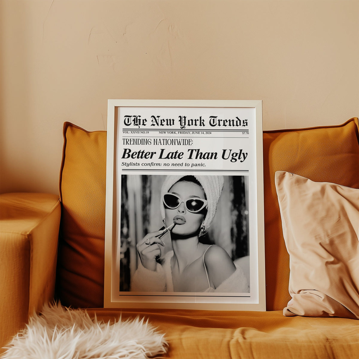 Woman applying lipstick mock newspaper print in a white frame leaning on a mustard velvet sofa