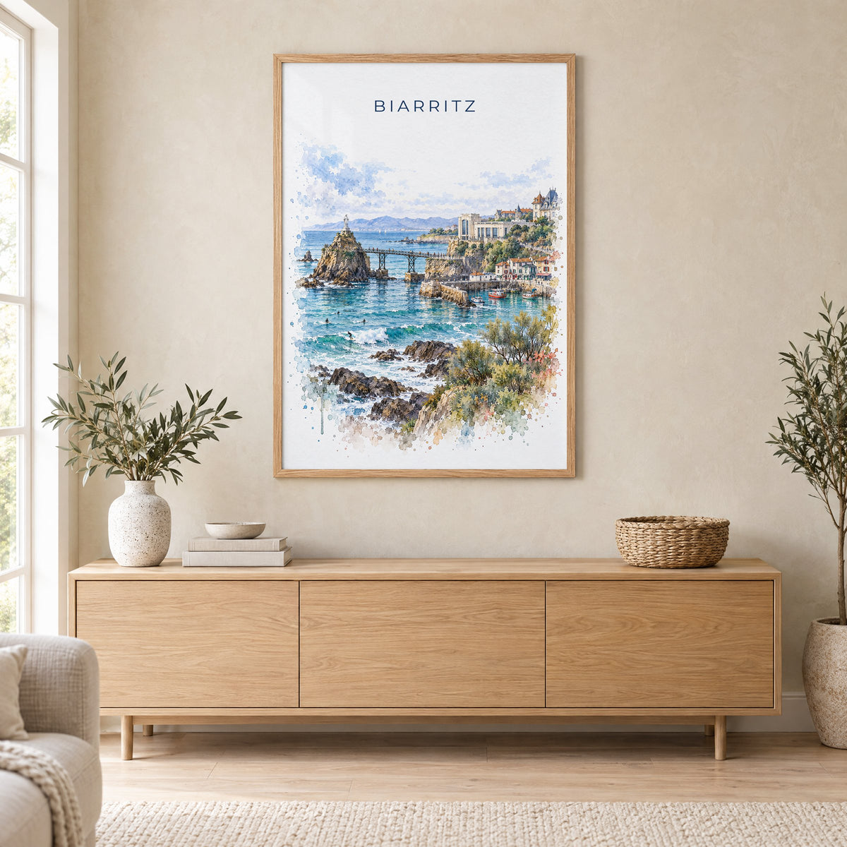 Biarritz watercolor print in an oak frame above a light wood sideboard in a Scandinavian living room