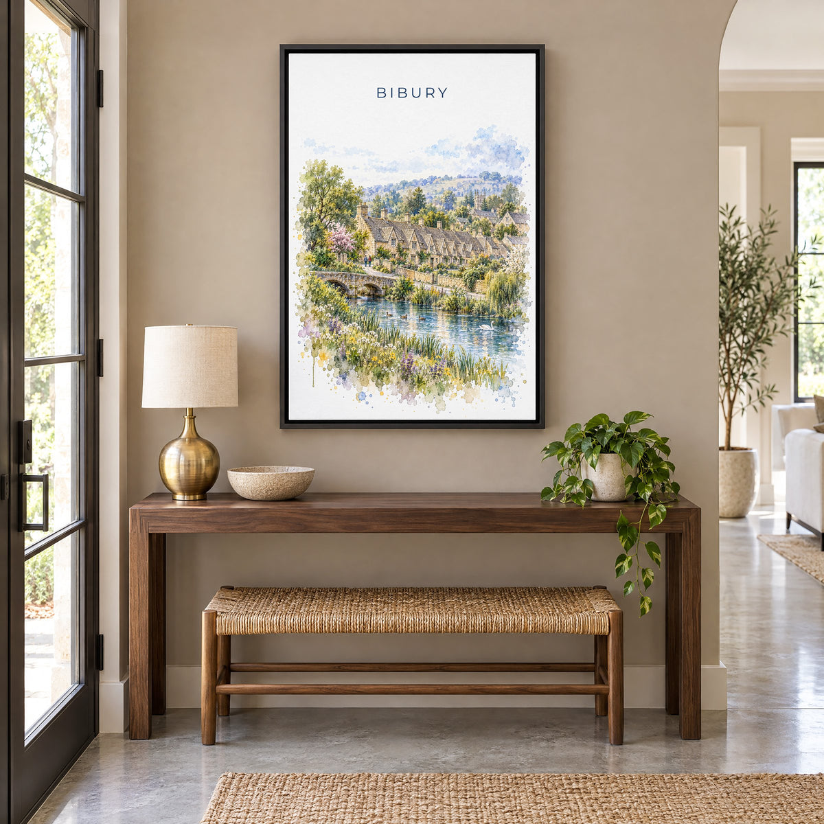 Bibury watercolor print as a black floater canvas above a walnut console and woven bench in an entryway