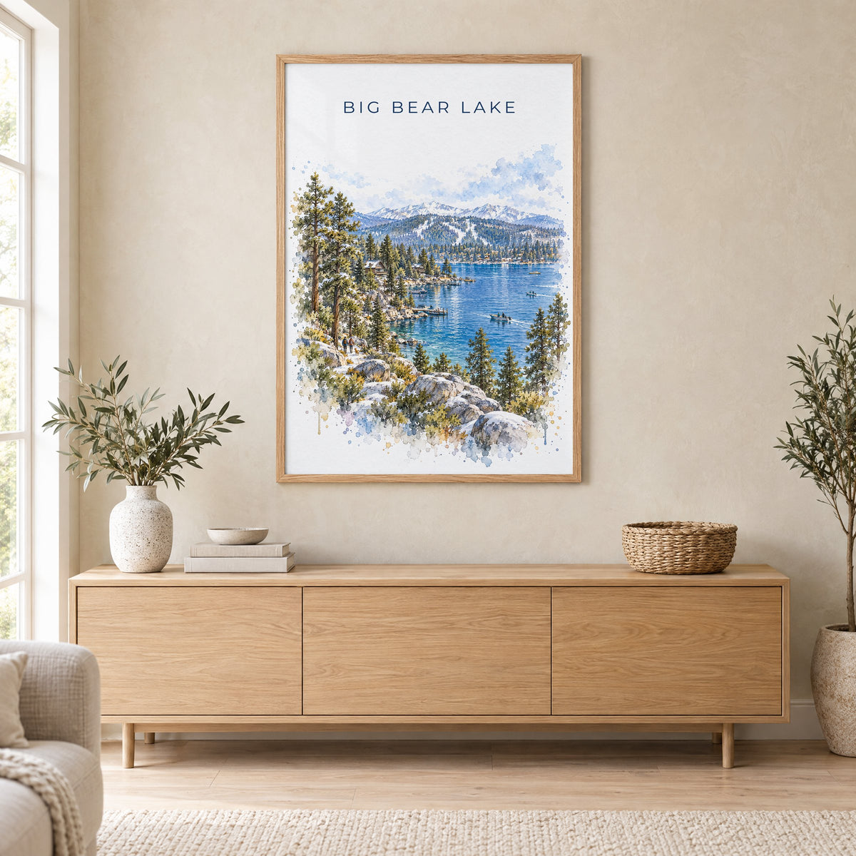 Big Bear Lake watercolor print in an oak frame above a light wood sideboard in a Scandinavian living room