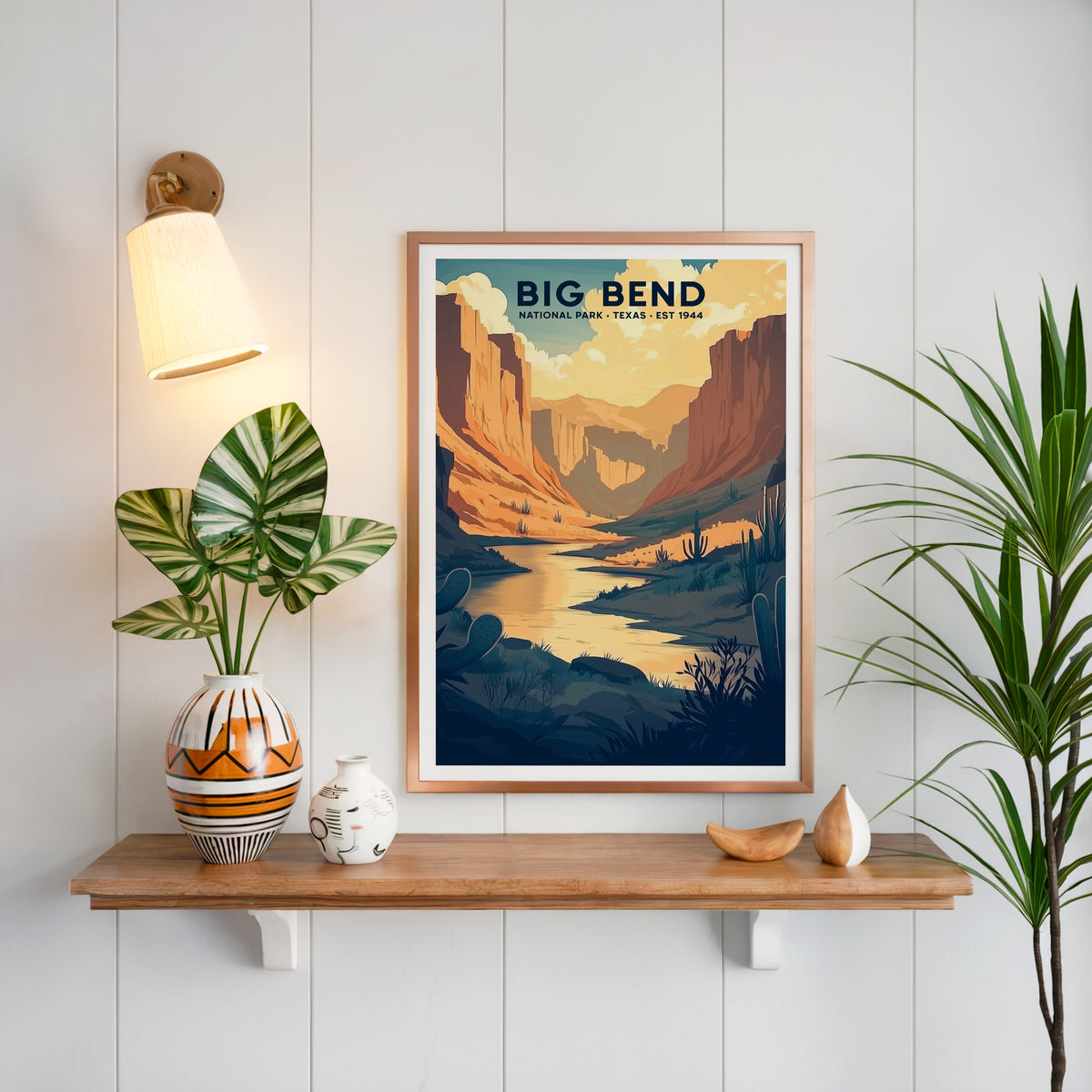 Big Bend National Park print in a copper frame above an oak shelf on white shiplap with a sconce