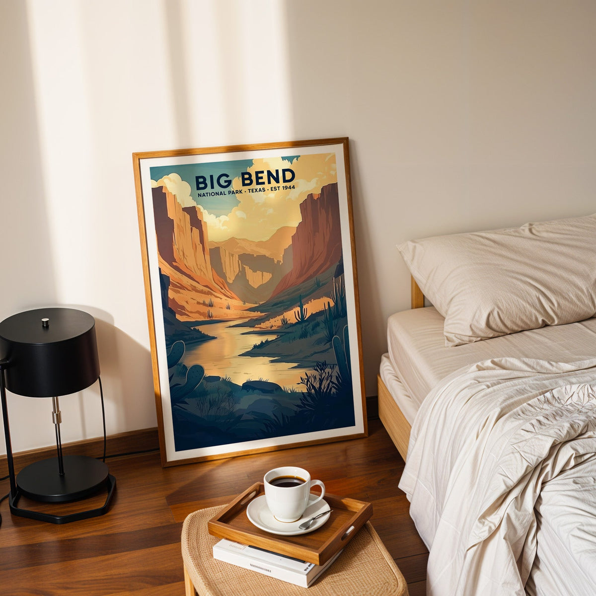 Big Bend National Park print in an oak frame leaning on a bedroom floor beside the bed and a tray