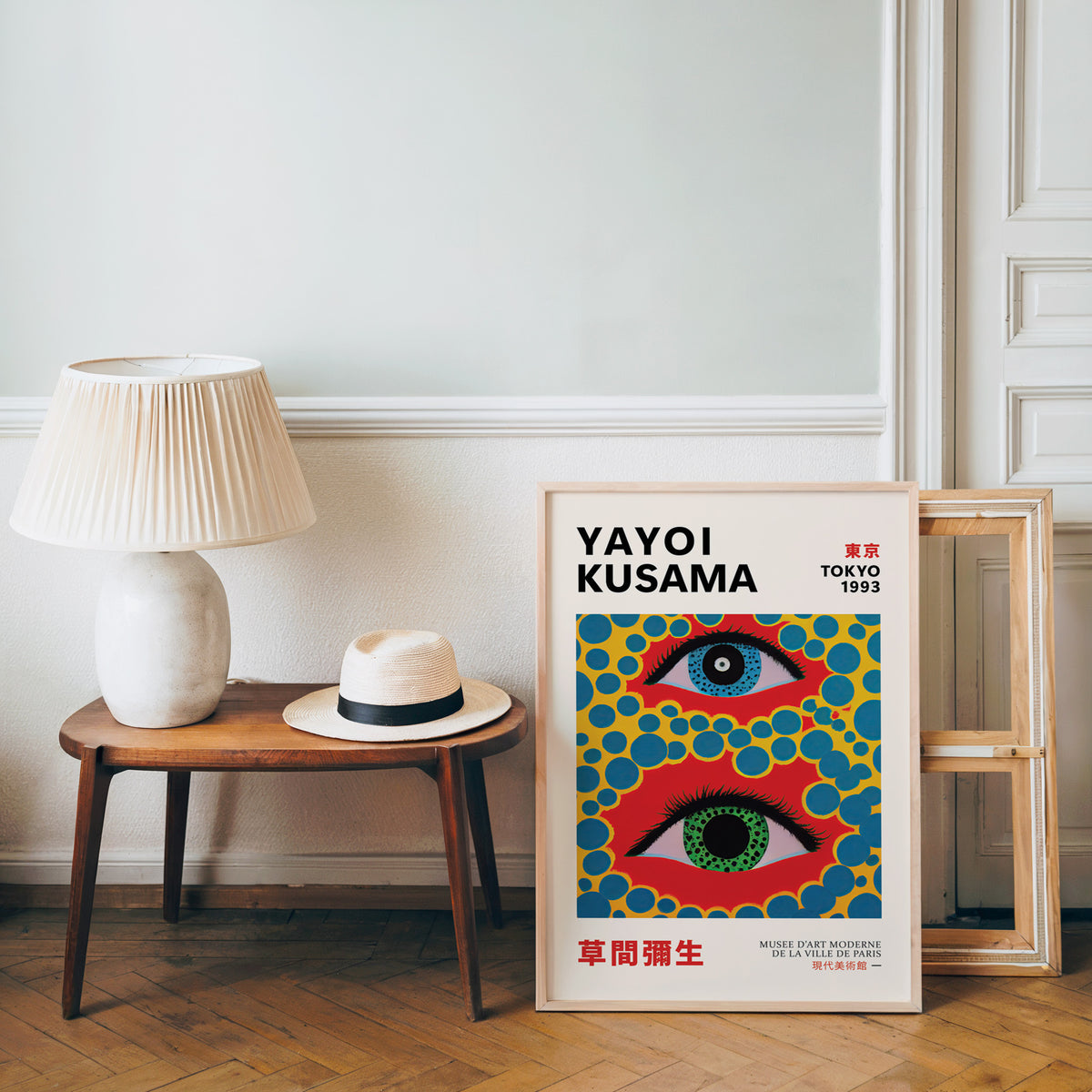 Yayoi Kusama inspired big eyes and blue dots print beside a bench and straw hat