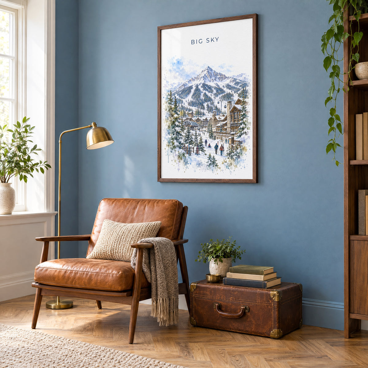 Big Sky watercolor print in a walnut frame on a blue wall above a leather armchair in a reading nook