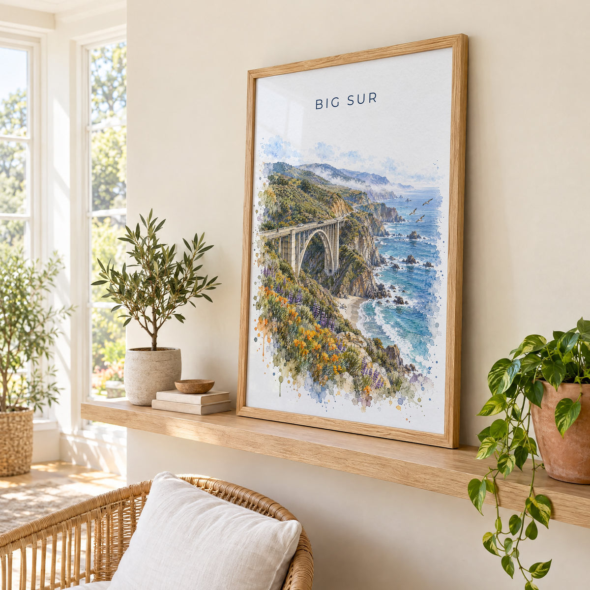 Big Sur watercolor print in an oak frame on a picture ledge in a sunlit sunroom