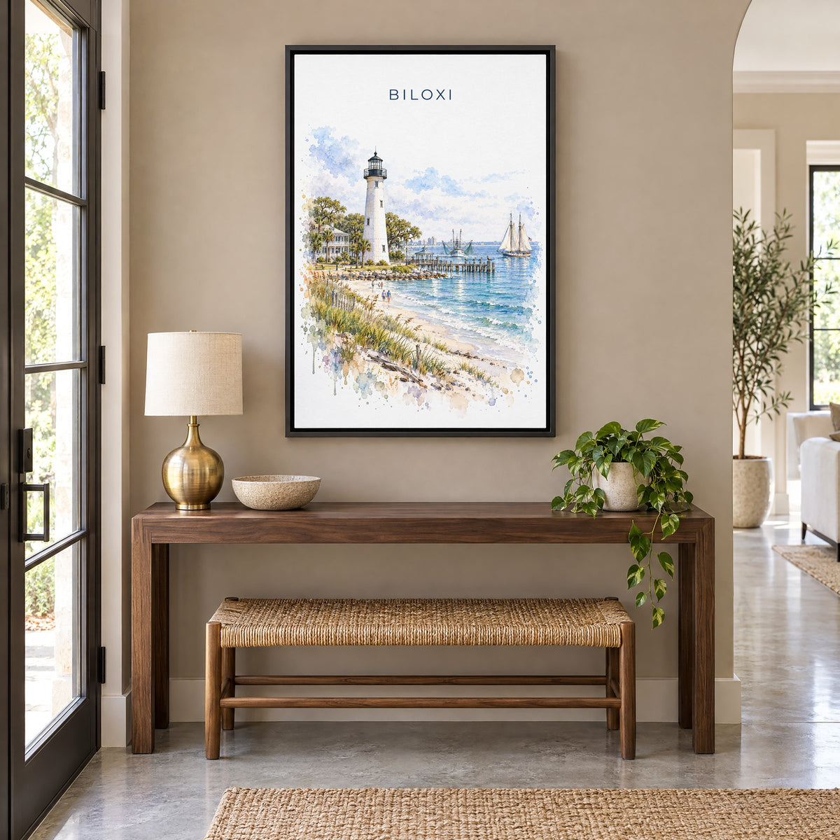 Biloxi watercolor print as a black floater canvas above a walnut console and woven bench in an entryway