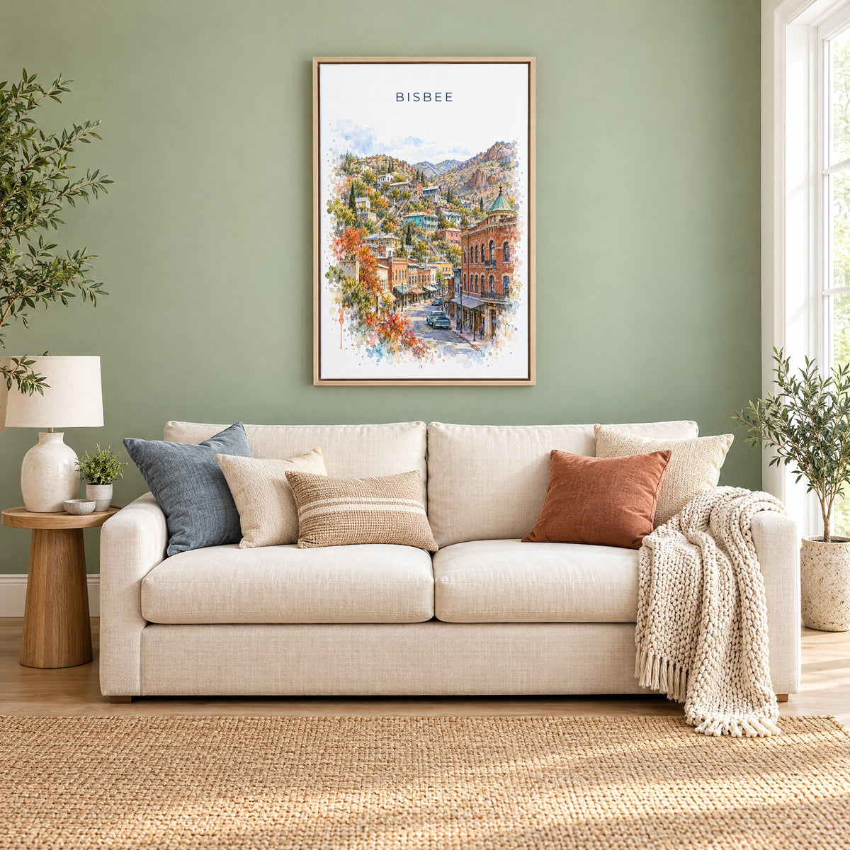 Bisbee watercolor print as a natural floater canvas above a cream linen sofa on a sage green wall
