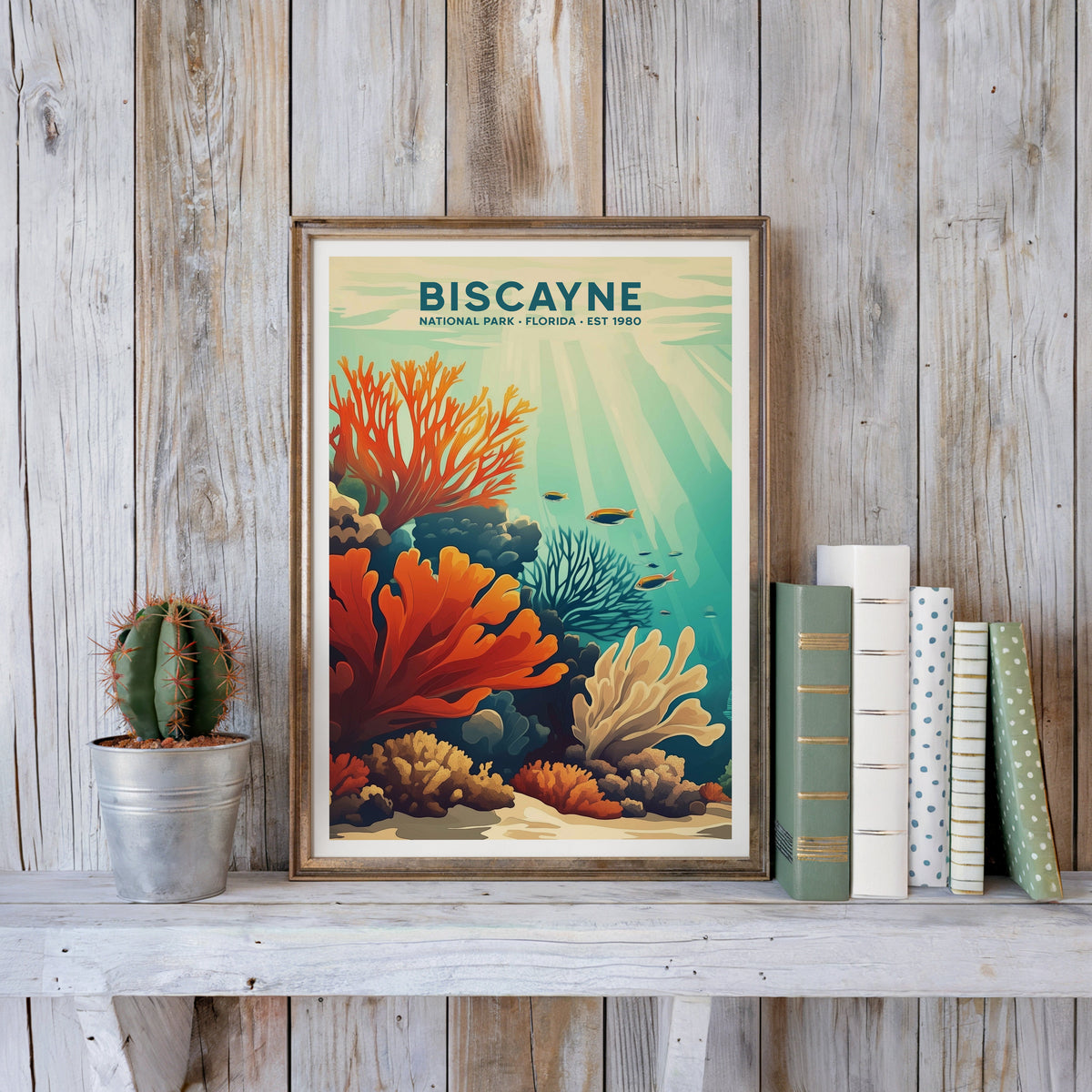 Biscayne poster in an antique gold frame against whitewashed farmhouse planks beside books