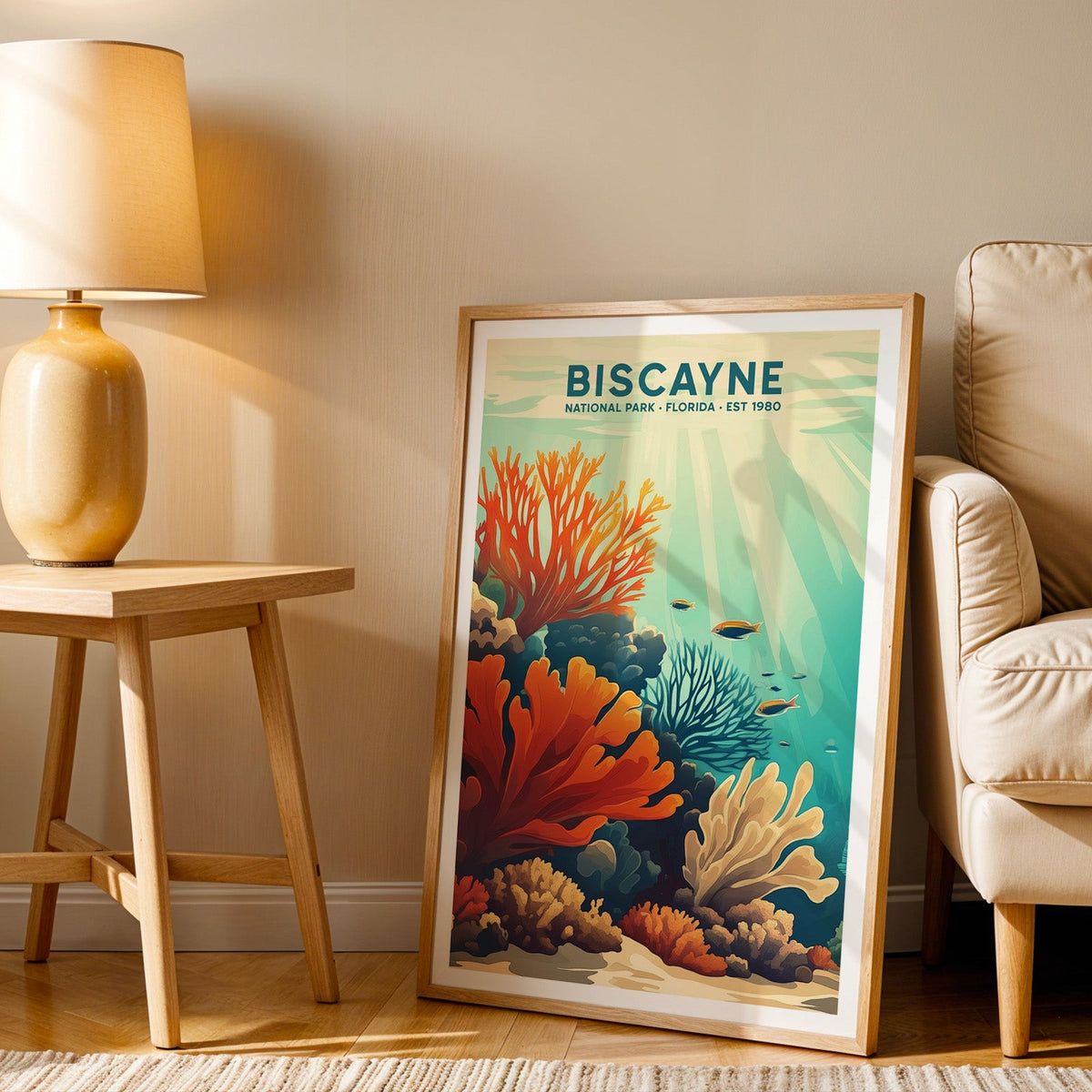 Biscayne print in an oak frame beside a cream armchair and an amber lamp in warm afternoon light