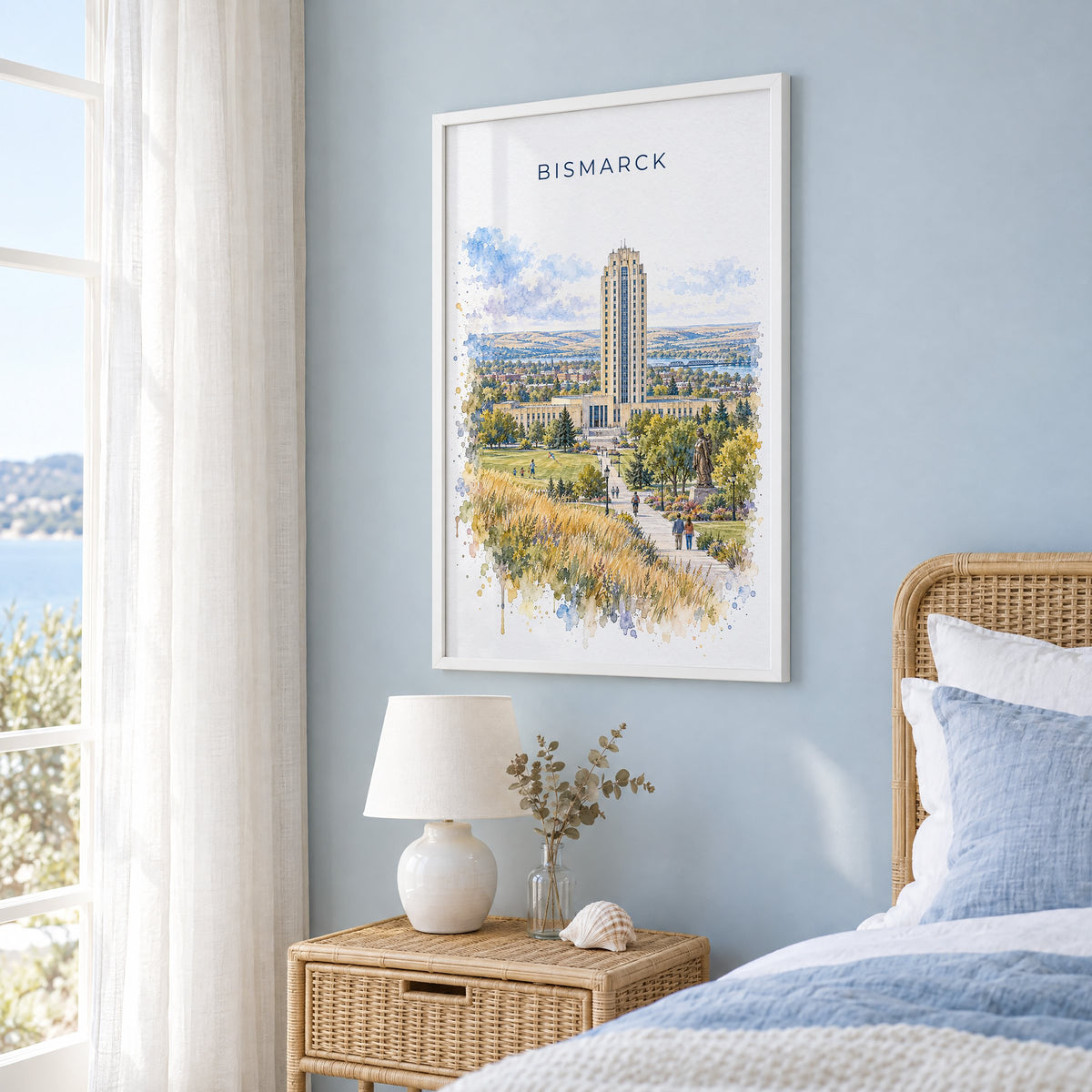 Bismarck watercolor print in a white frame on a pale blue wall beside a rattan bed in a coastal bedroom