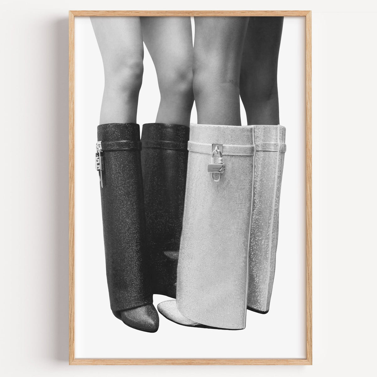 Black and silver crystal knee-high boots print in a light oak frame on a plain white wall