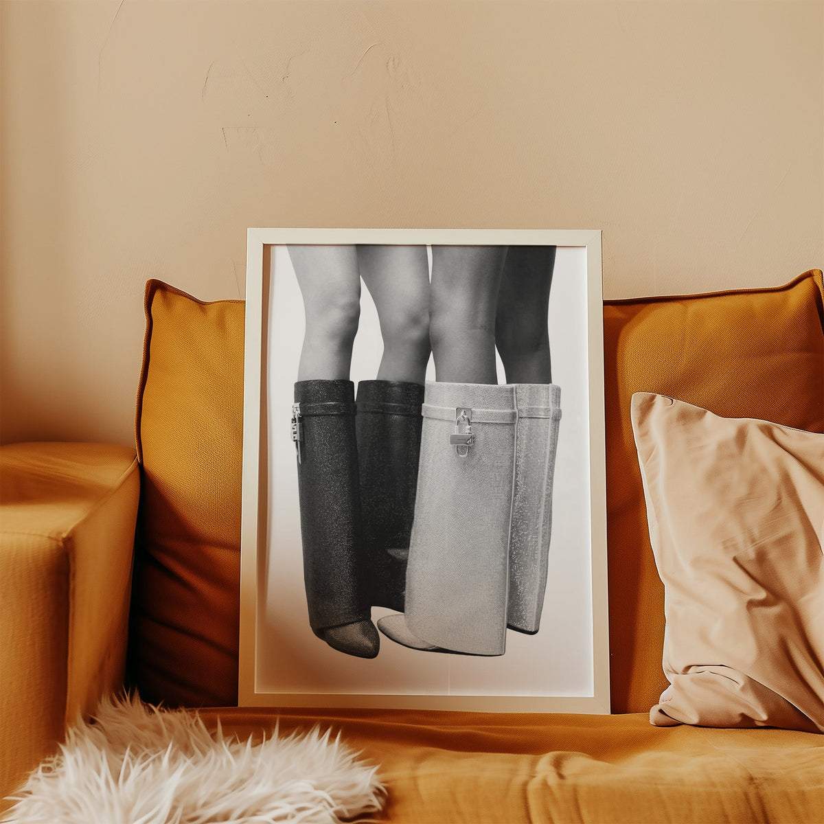 Black and silver crystal knee-high boots print in a white frame leaning on a mustard velvet sofa