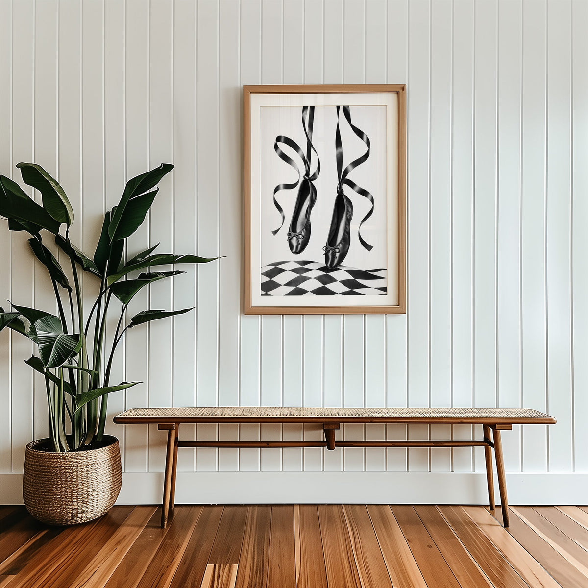 Black ballet flats on ribbons over checkerboard print in a wood frame with a white mat above a cane bench