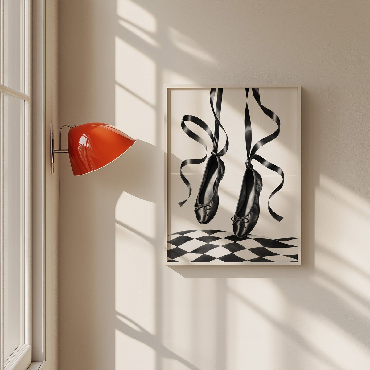 Black ballet flats on ribbons over checkerboard print in a white frame on a sunlit wall beside a red sconce