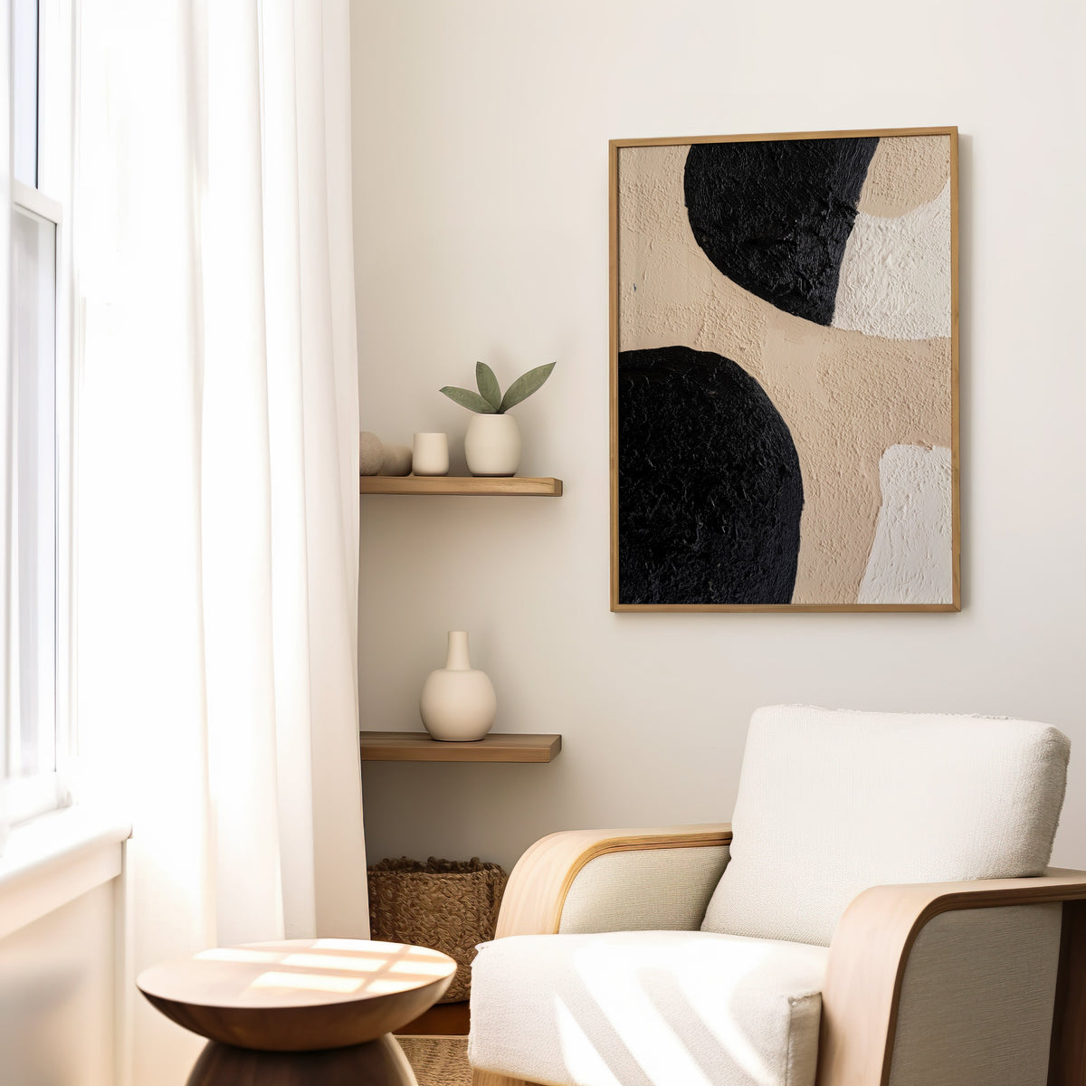 Black and beige textured shapes abstract print in a slim oak frame above a cream boucle armchair by floating shelves