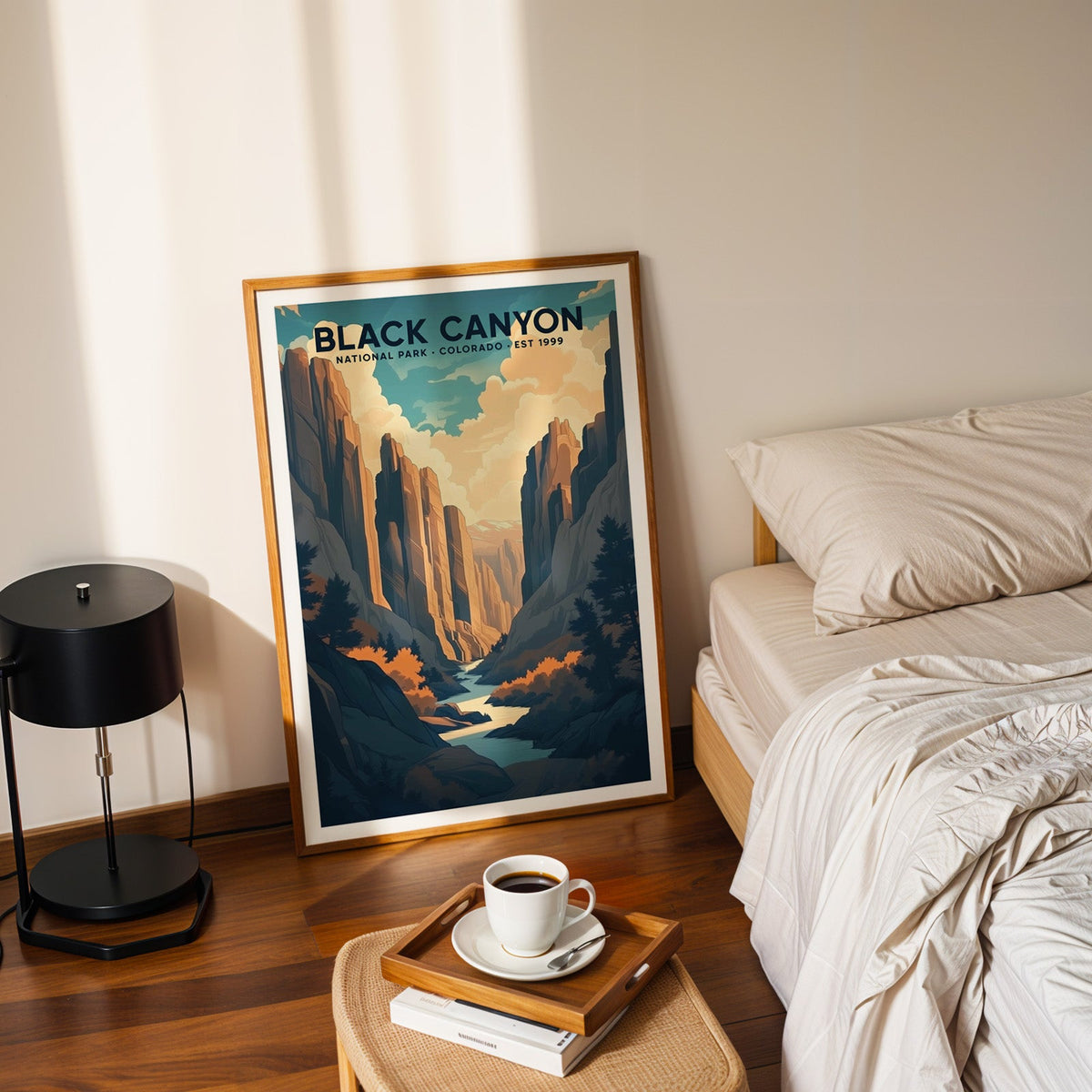 Black Canyon of the Gunnison print in an oak frame leaning on a bedroom floor beside the bed