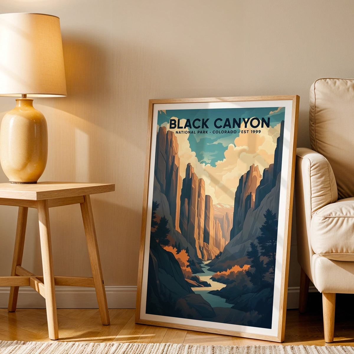 Black Canyon print in an oak frame beside a cream armchair and an amber lamp in warm light