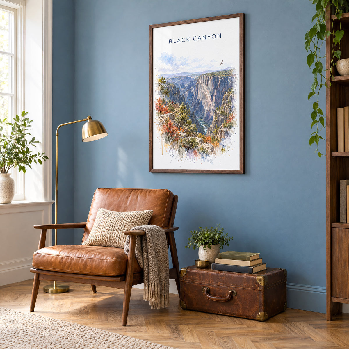 Black Canyon of the Gunnison National Park watercolor in a walnut frame on a blue wall above a leather armchair in a reading