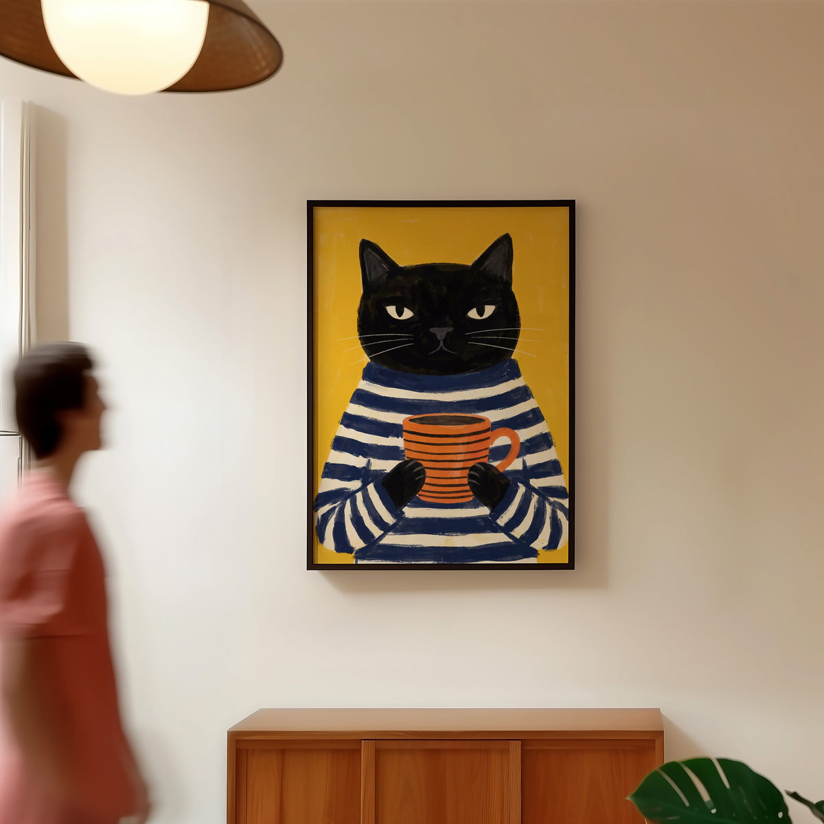 Yellow cat coffee print in a black frame in a hallway under a rattan pendant