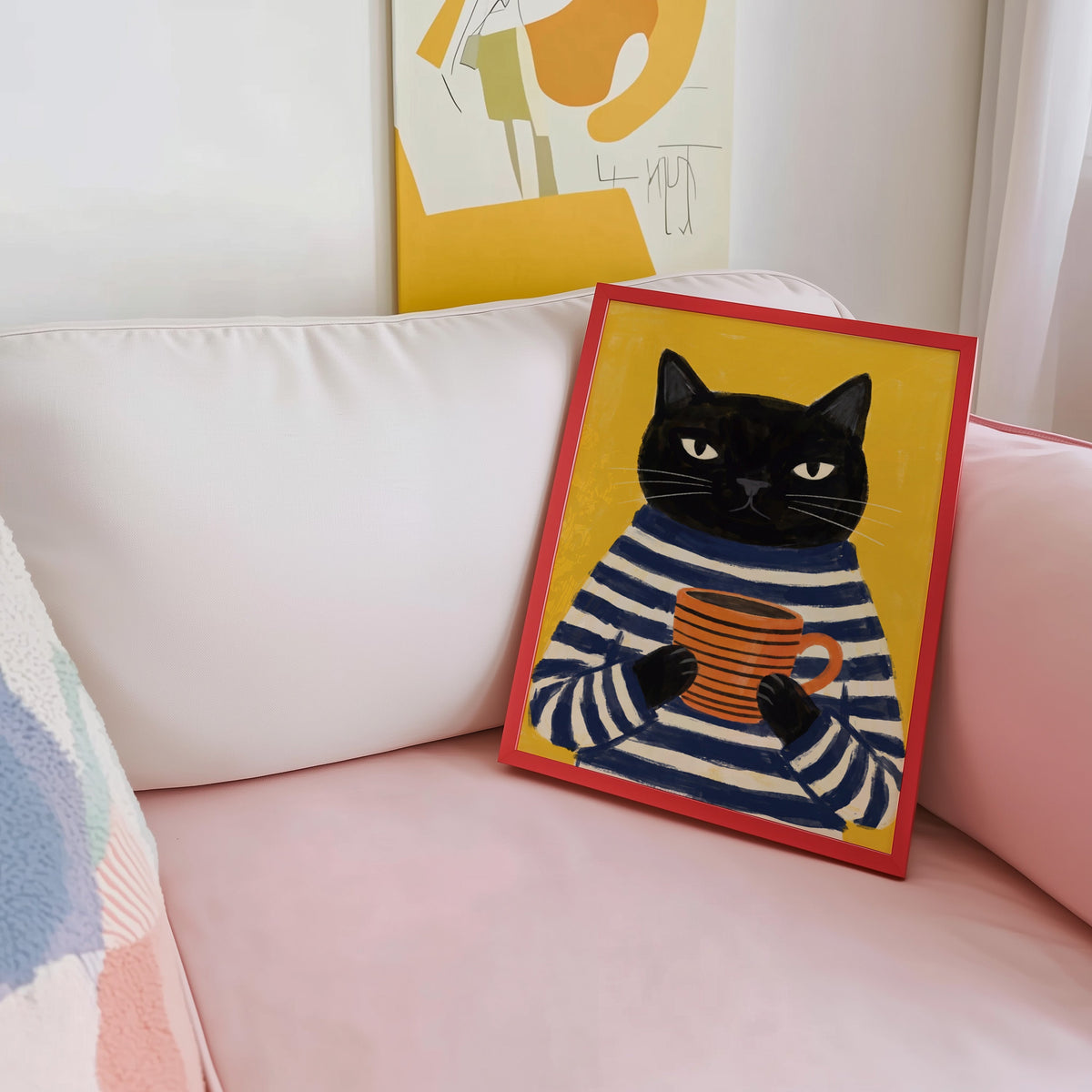 Breton stripe black cat print shown in a red frame leaning on a blush pink sofa