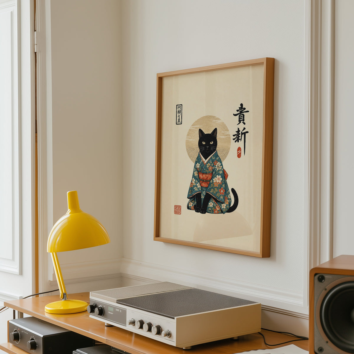 Black cat in floral kimono poster in an oak frame above a vintage hi-fi shelf with a yellow desk lamp