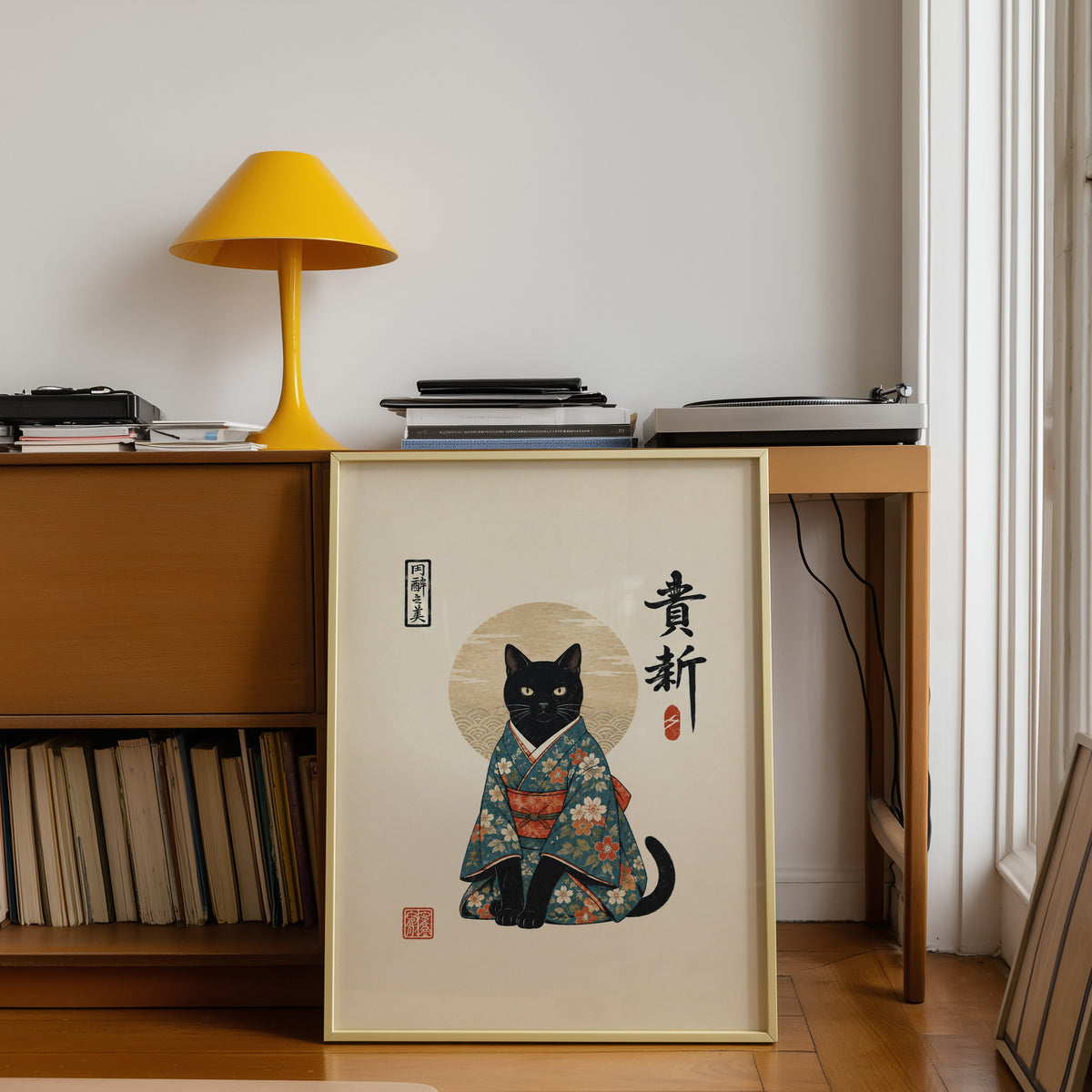 Black cat in floral kimono poster shown in a gold frame leaning under a teak desk with a yellow lamp