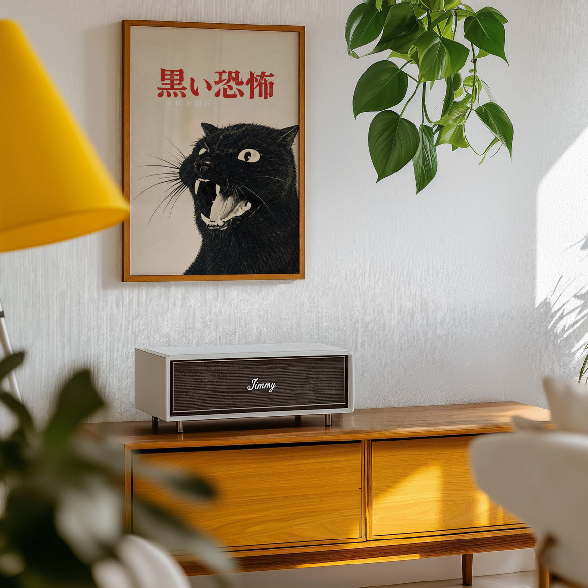 Hissing black cat kanji poster in an oak frame above a teak mid-century sideboard with trailing pothos