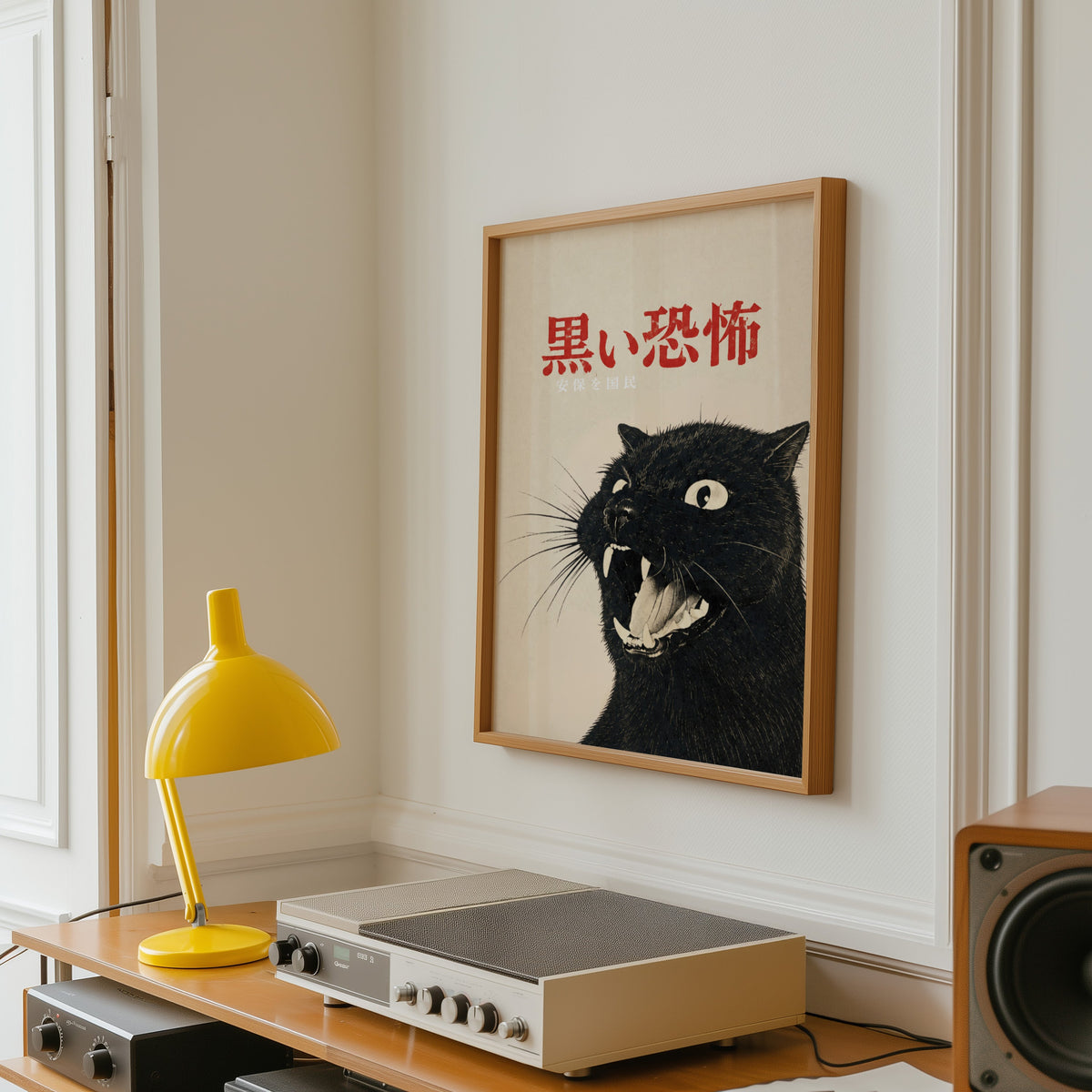 Hissing black cat kanji poster in an oak frame above a vintage hi-fi shelf with a yellow desk lamp