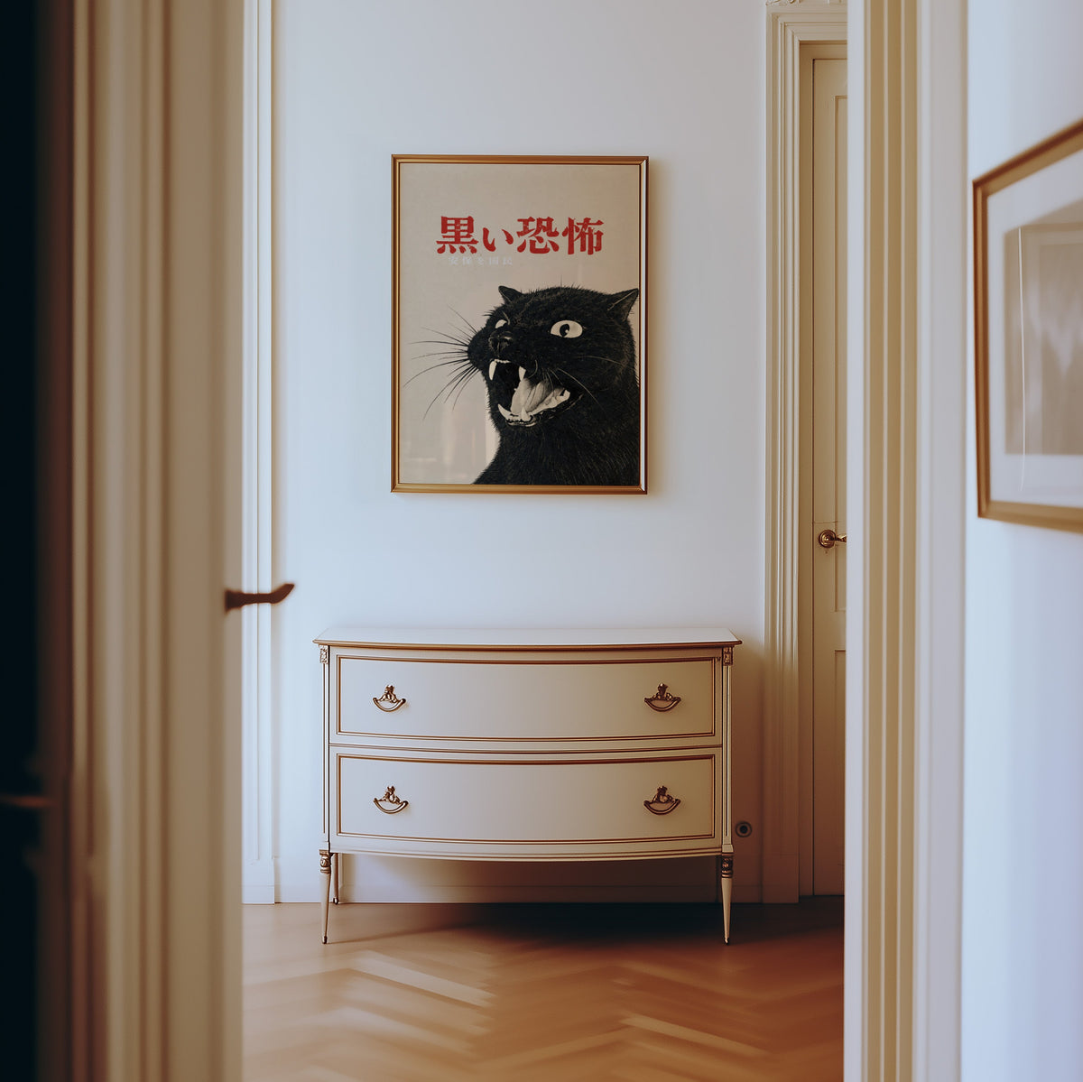 Hissing black cat kanji poster shown in a gold frame in a hallway above a cream dresser