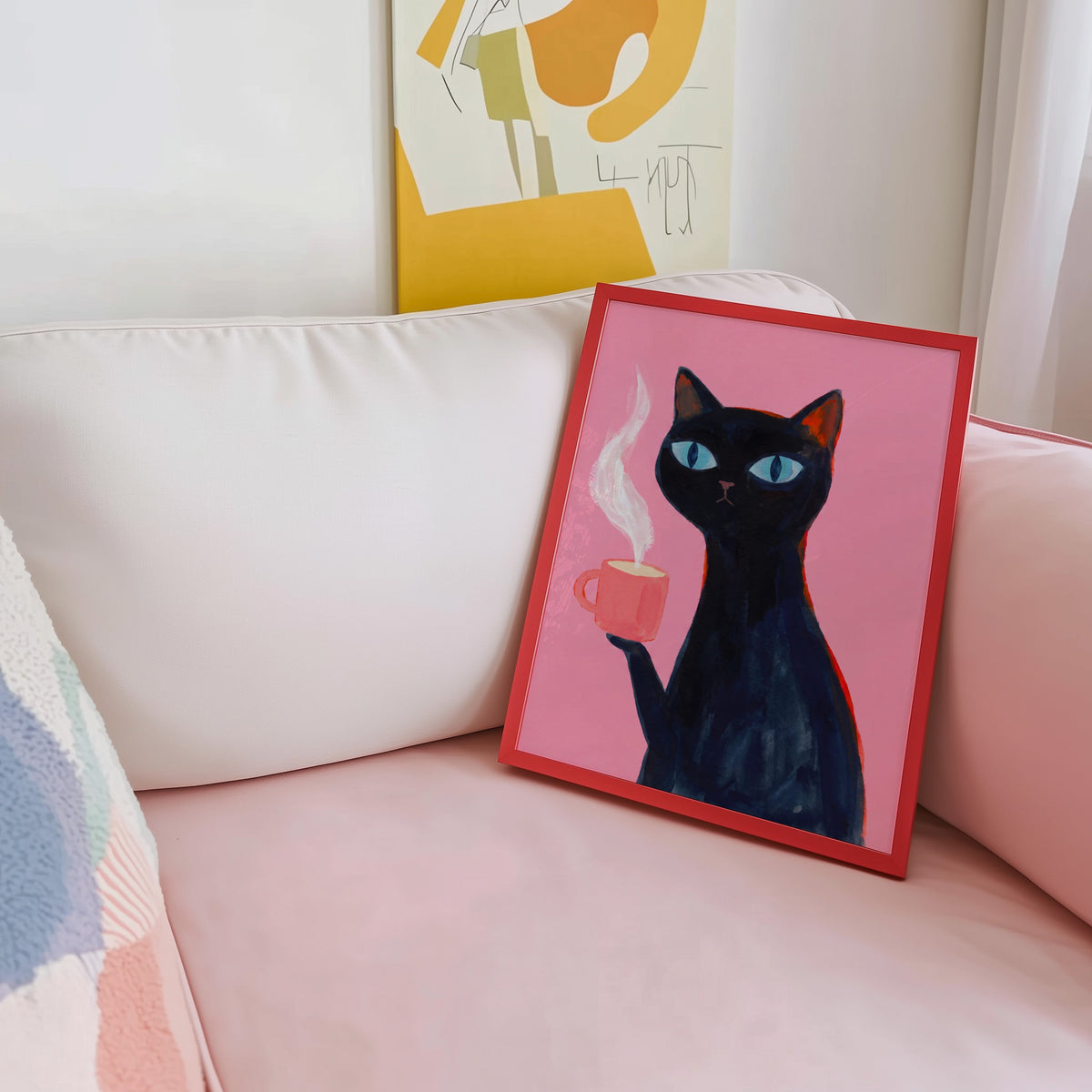 Steaming mug cat print shown in a red frame leaning on a blush pink sofa