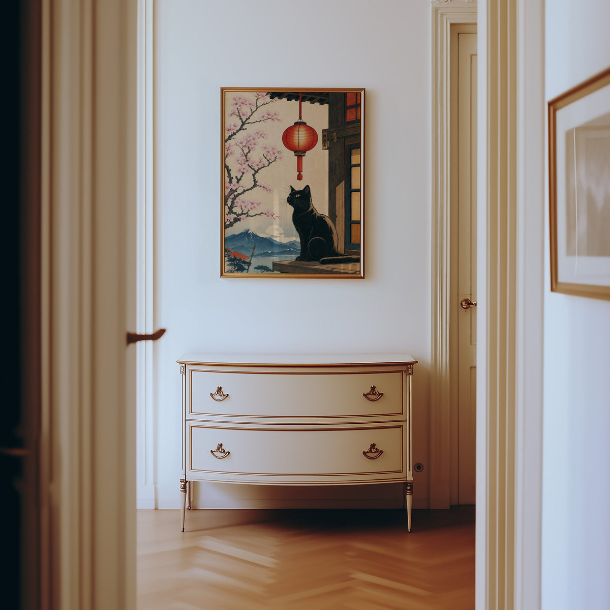 Black cat and red lantern poster shown in a gold frame in a hallway above a cream dresser