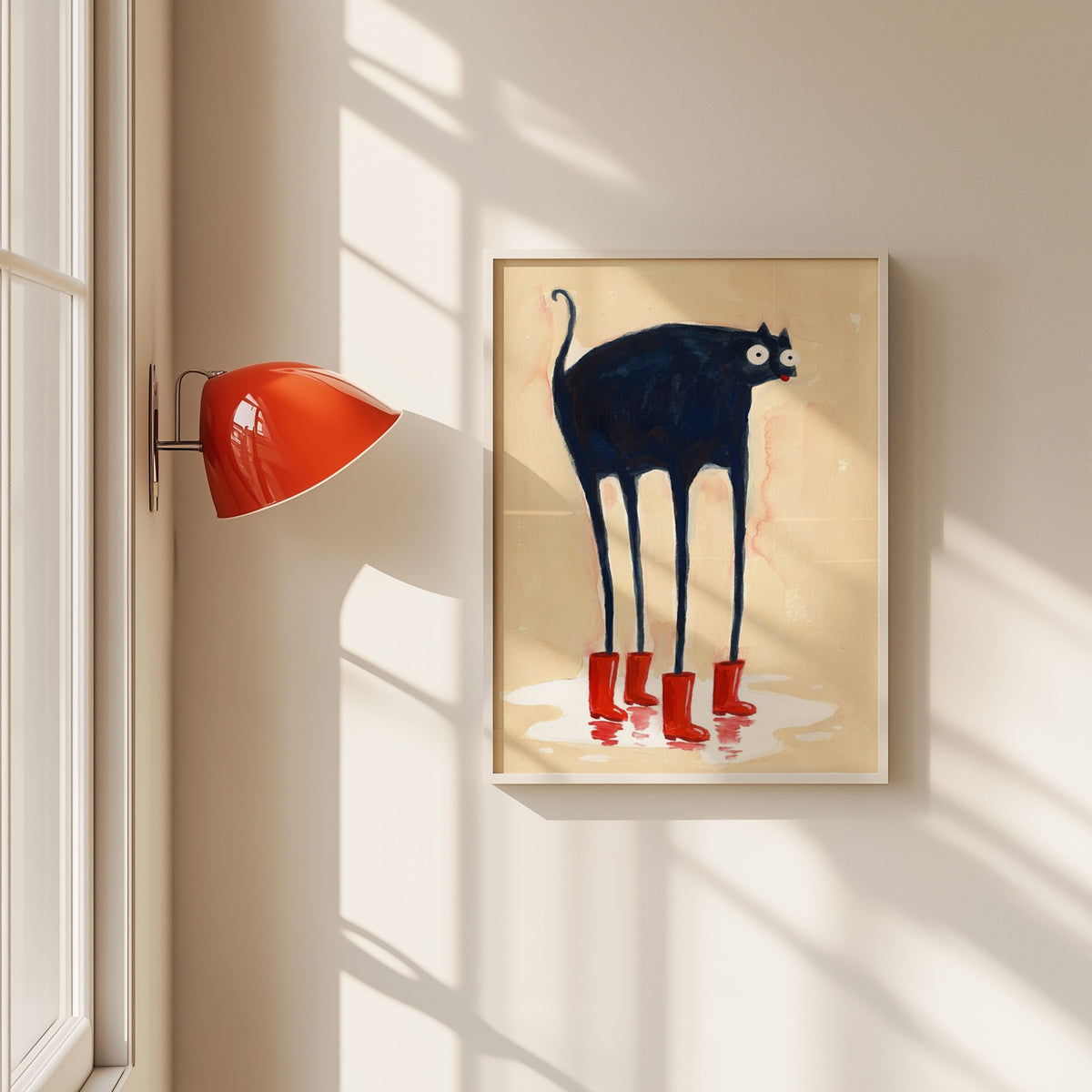 Black cat in red rain boots print in a white frame beside a red wall sconce