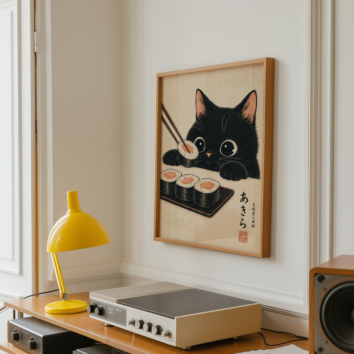 Black cat salmon sushi poster in an oak frame above a vintage hi-fi shelf with a yellow desk lamp