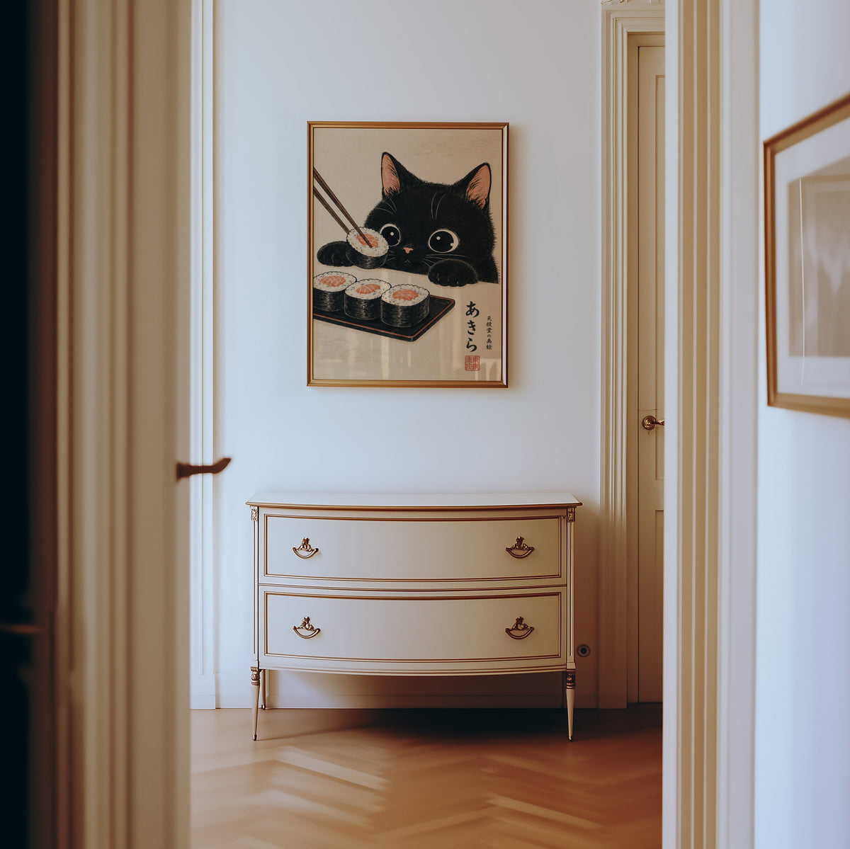 Black cat salmon sushi poster shown in a gold frame in a hallway above a cream dresser